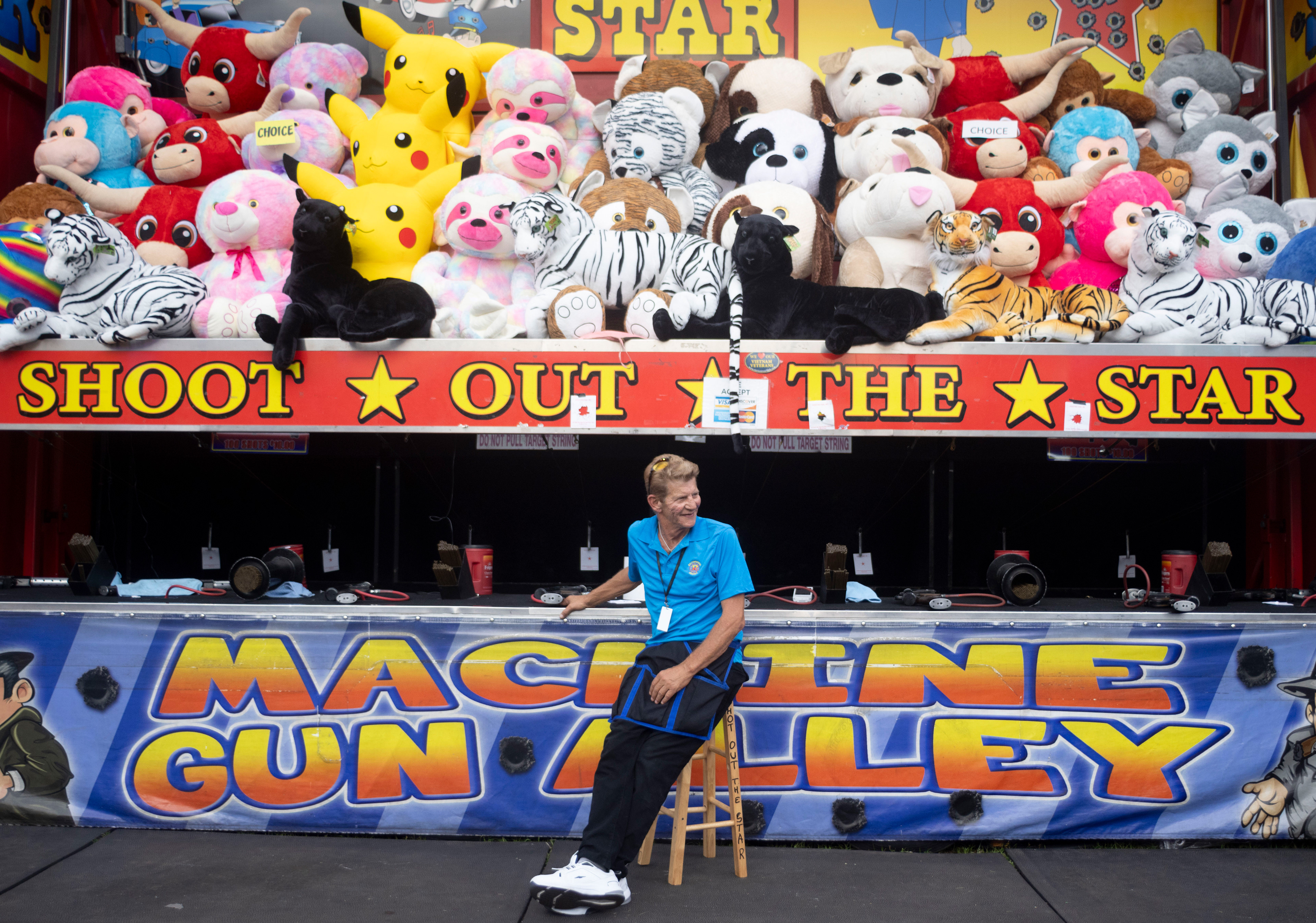 James Craft of Portsmouth, Ohio, smiles at fairgoers as he sits outside of the game he works at the Georgia National Fairgrounds and Agriculture Center on Oct. 5, 2024. This is Craft's 47th year working at the fair.
