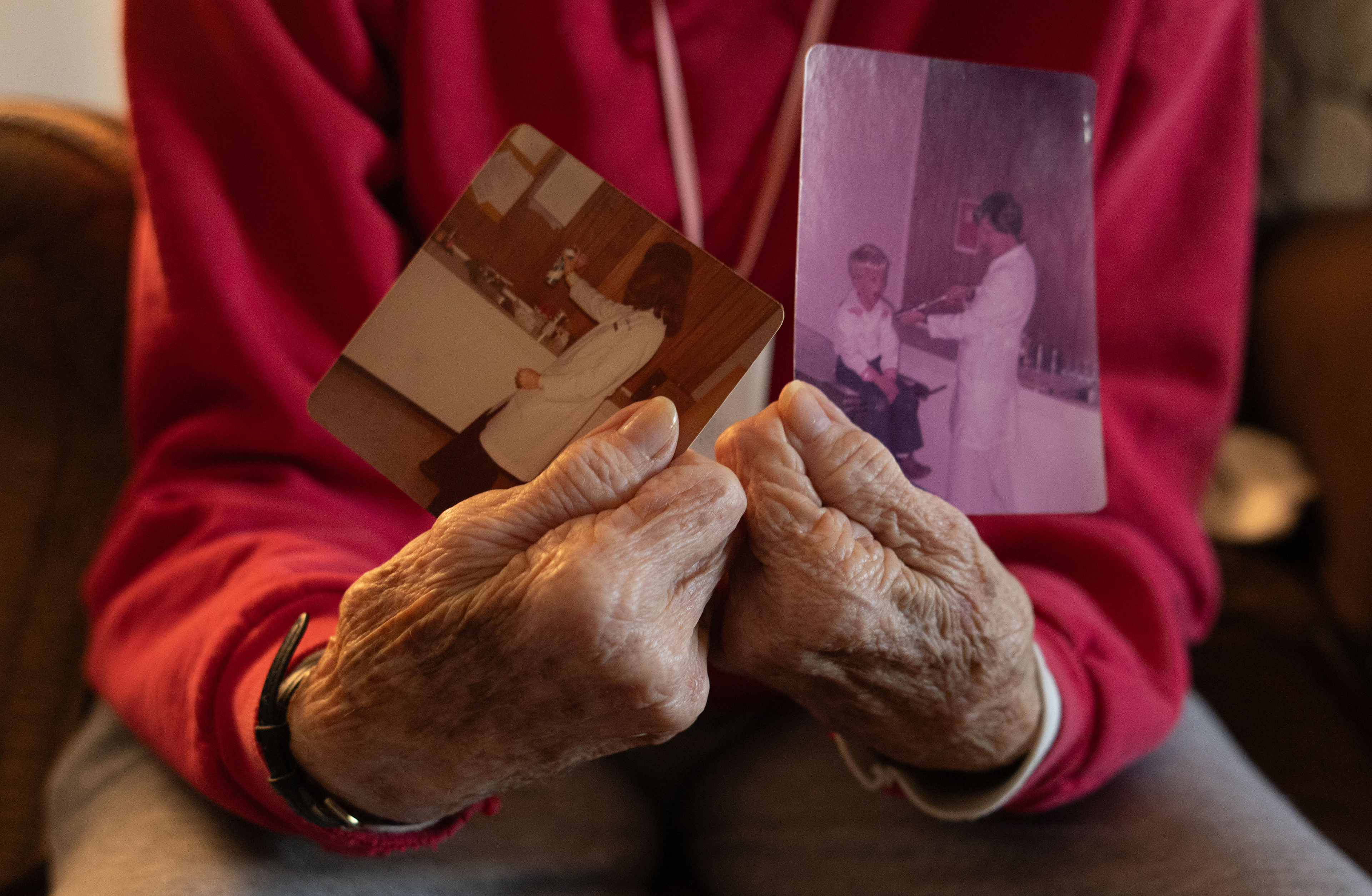 Judith Paul, 85, holds two photos inside her home in Oglethorpe County, Georgia on March 27, 2025. The photos are located inside Oglethorpe Primary Health Care Center, the first ever healthcare facility to open in Crawford, Georgia in 1979. They depict Anne Cummings, the center's first nurse practitioner, and her son, Jay Paul, who is recieving an examination from her. 