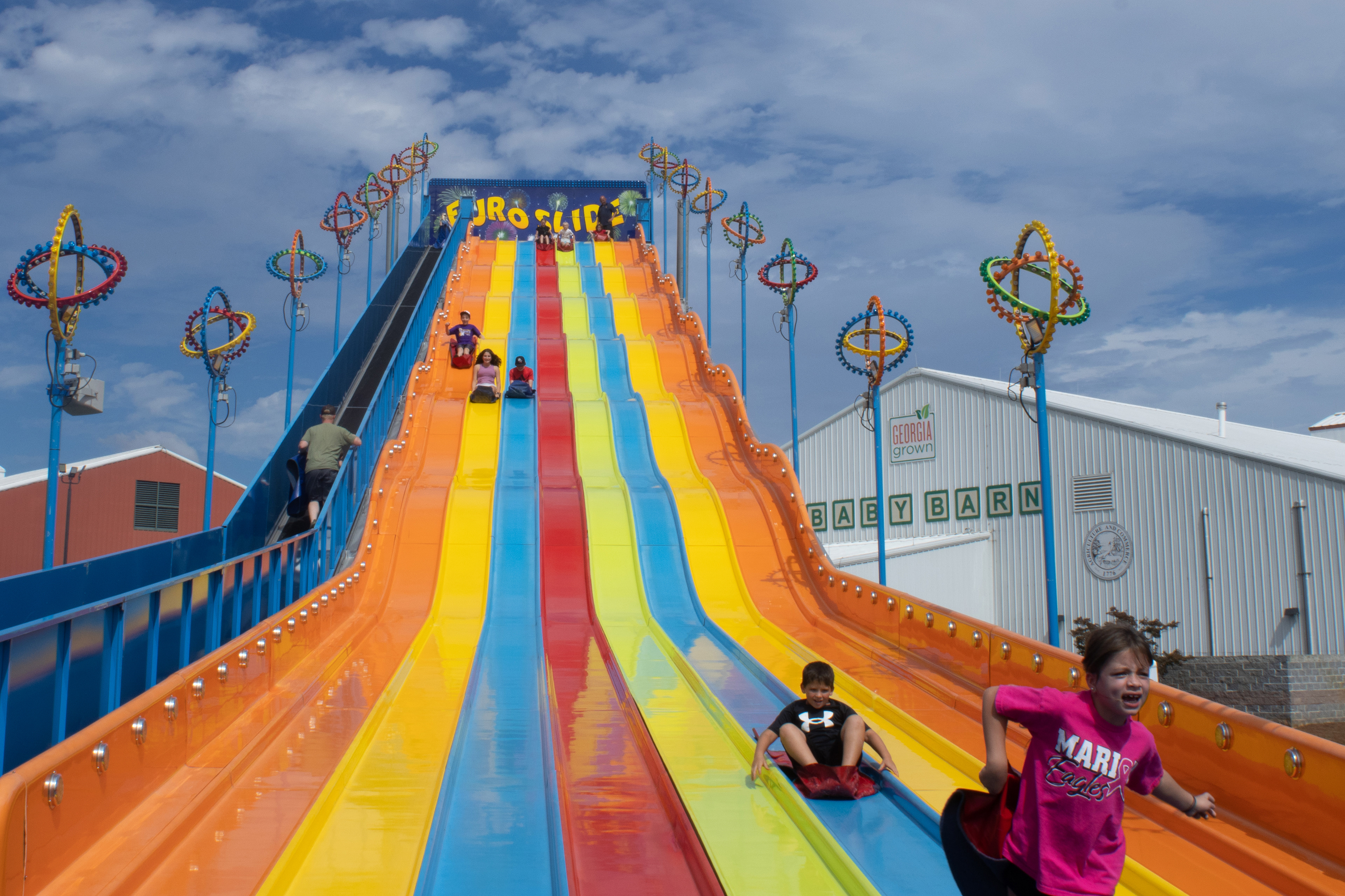 Fairgoers race down a giant slide at the Georgia National Fairgrounds and Agriculture Center on Oct. 5, 2024.