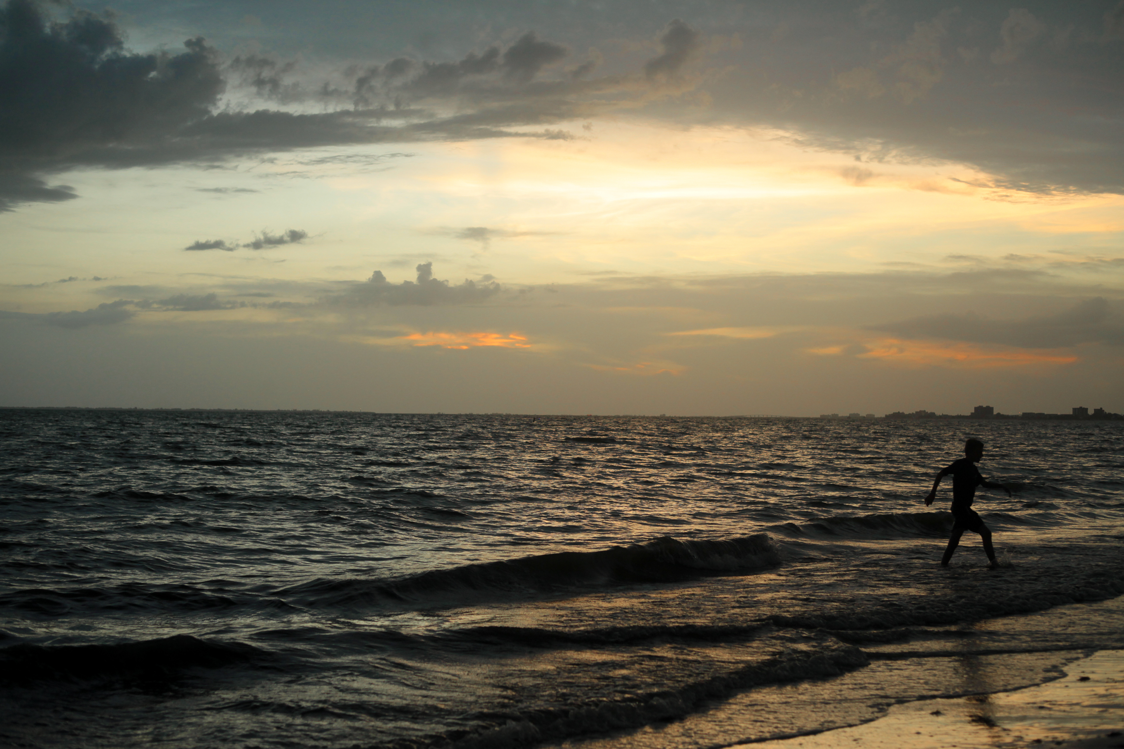 A young boy runs to shore after playing in the ocean by himself in Fort Myers, Florida on July 4, 2021.