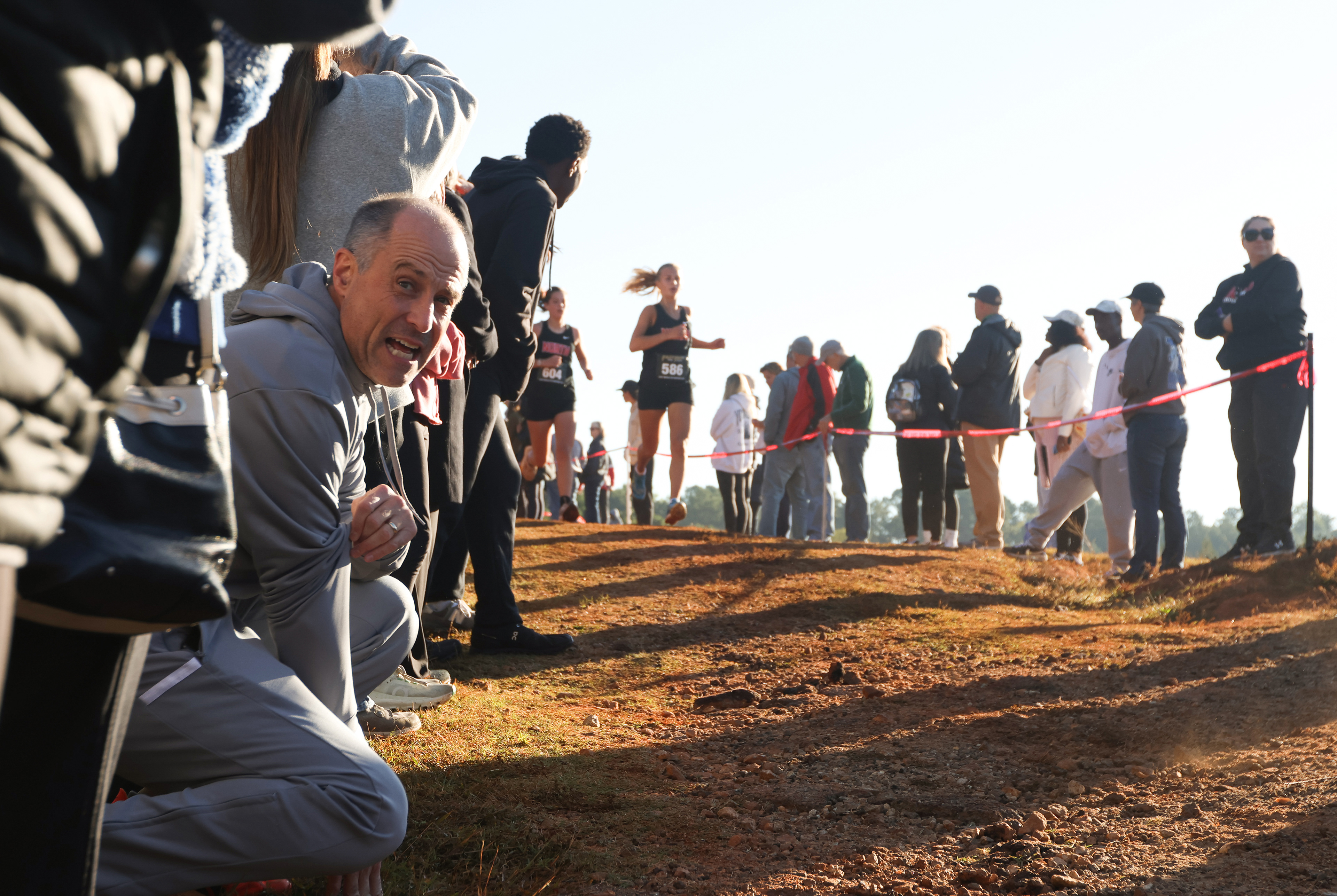 Fans yell and cheer for runners who are racing in the Women's Varsity 5k at the North Oconee Cross Country Invitational on Oct. 19, 2024.