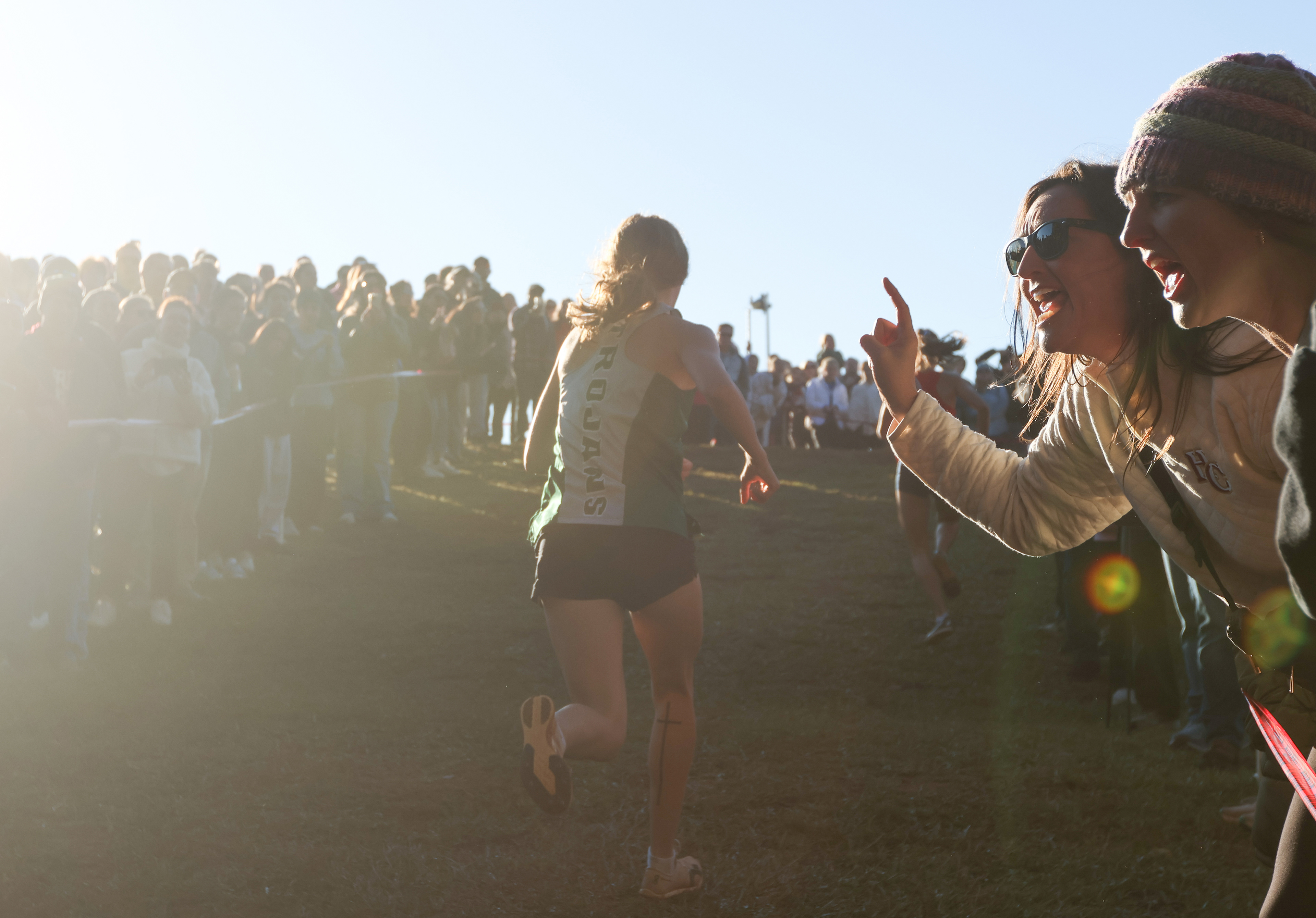 A crowd cheers on runners who are racing in the Women's Varsity 5k at the North Oconee Cross Country Invitational on Oct. 19, 2024