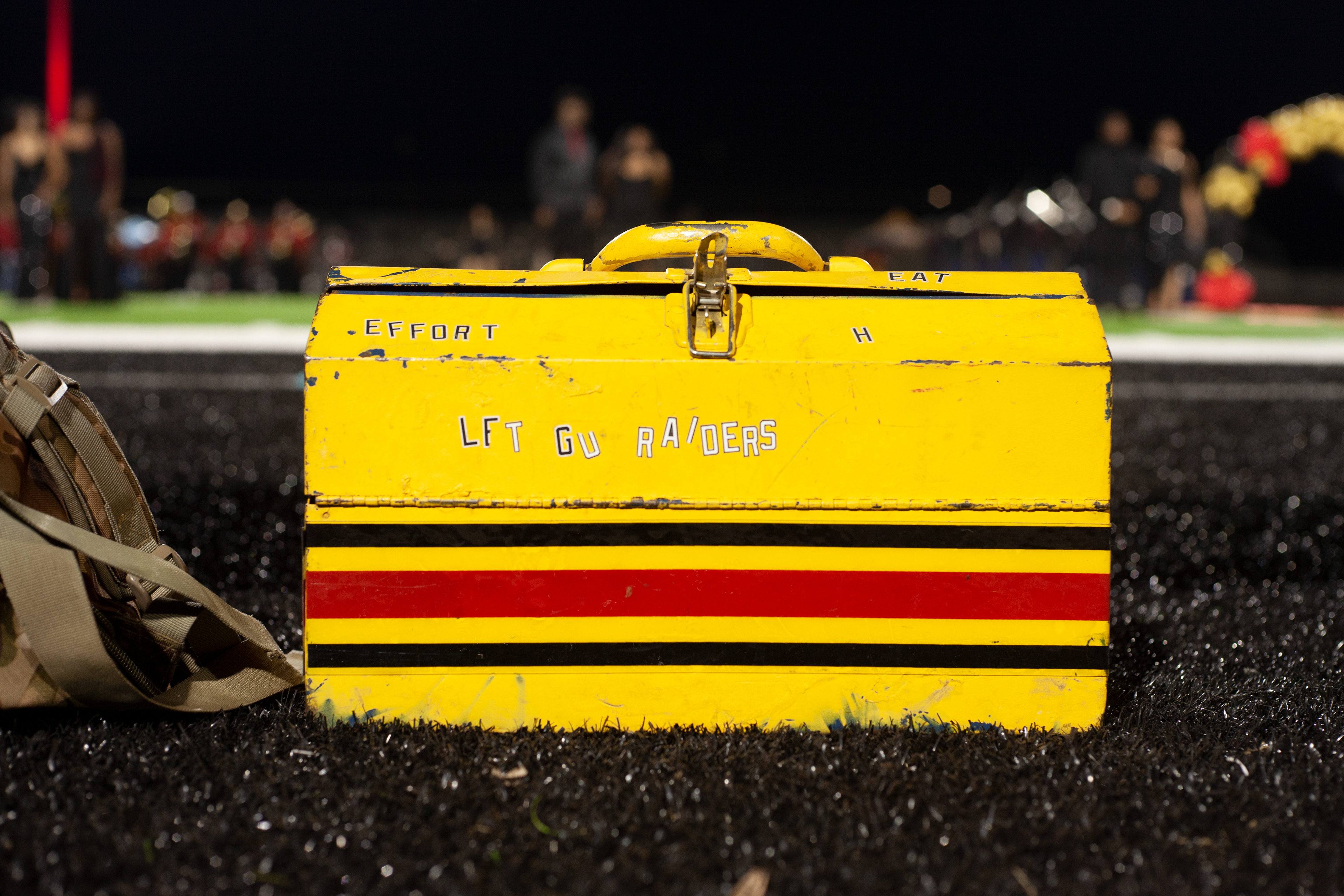 A box reading "let(s) go Raiders" sits near the bench of Northeast High School's football team at Ed Defore Sports Complex on Oct. 7, 2022. It is Northeast High School's homecoming game . It's Northeast High School's homecoming game, and homecoming court nominees wait for this years winners to be announced during half time. 