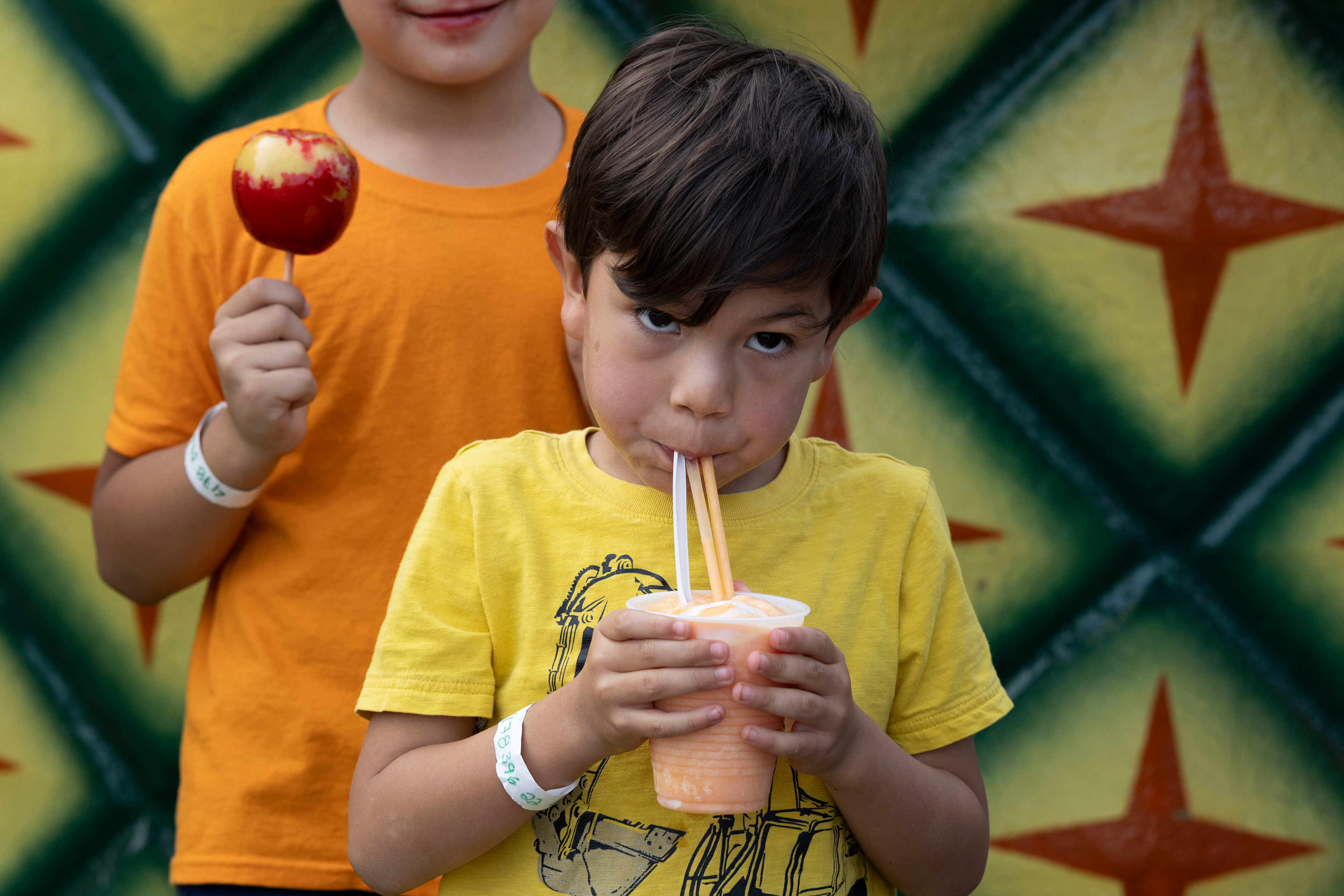 David Bonilla of Warner Robins, Georgia sips on dole whip alongside his brother, Alejandro Bonilla, at the Georgia National Fairgrounds and Agriculture Center on Oct. 5, 2024.