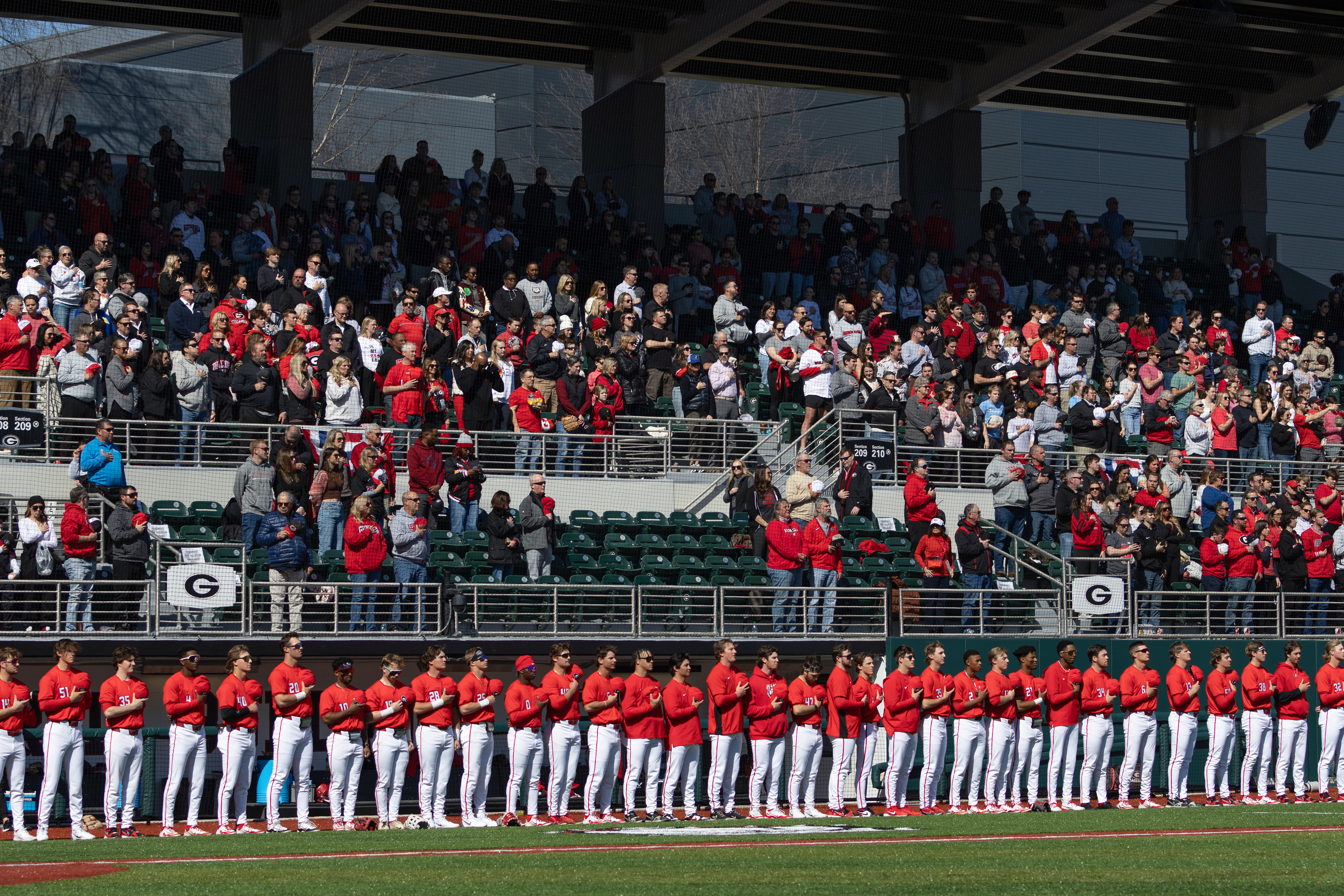Georgia baseball players stand for the national anthem before a game between opposing team UIC and Georgia at Foley Field in Athens, Georgia, on Saturday, Feb. 22, 2022. Georgia won 10-4. 
