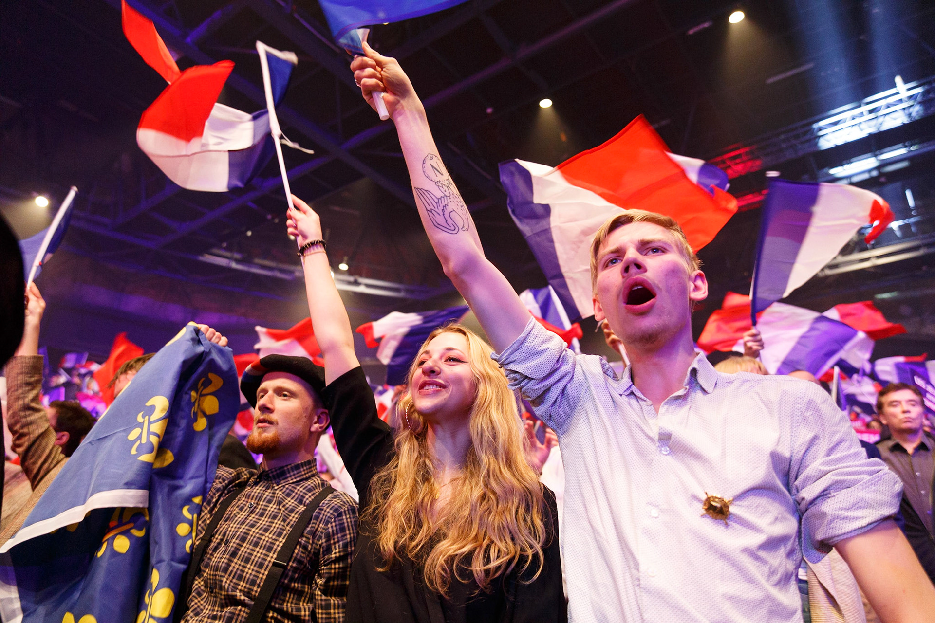 Des jeunes soutiens d’Eric Zemmour agitent des drapeaux Français et aux fleurs de lys pendant le discours du candidat. Eric Zemmour participe à son dernier meeting avant le premier tour, le 07 avril 2021. Cette réunion publique à Paris, réunit les jeunes avec Zemmour. PARIS, France - 07/04/2022