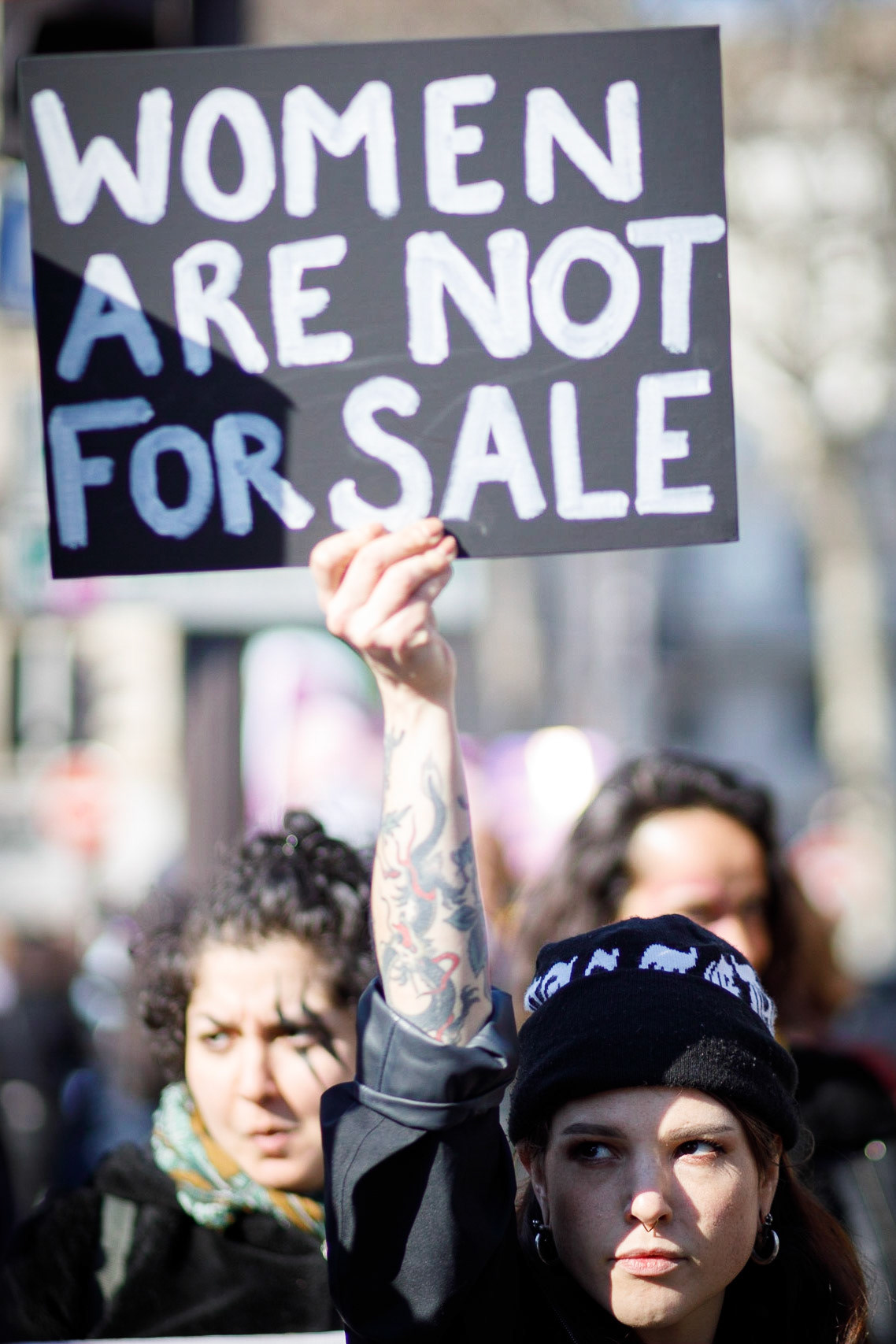 Une manifestante porte une pancarte “Women are not for sale“ lors de la marche pour la journée internationale des droits des femmes à Paris, le 8 mars 2022.PARIS, France - 08/03/2022
