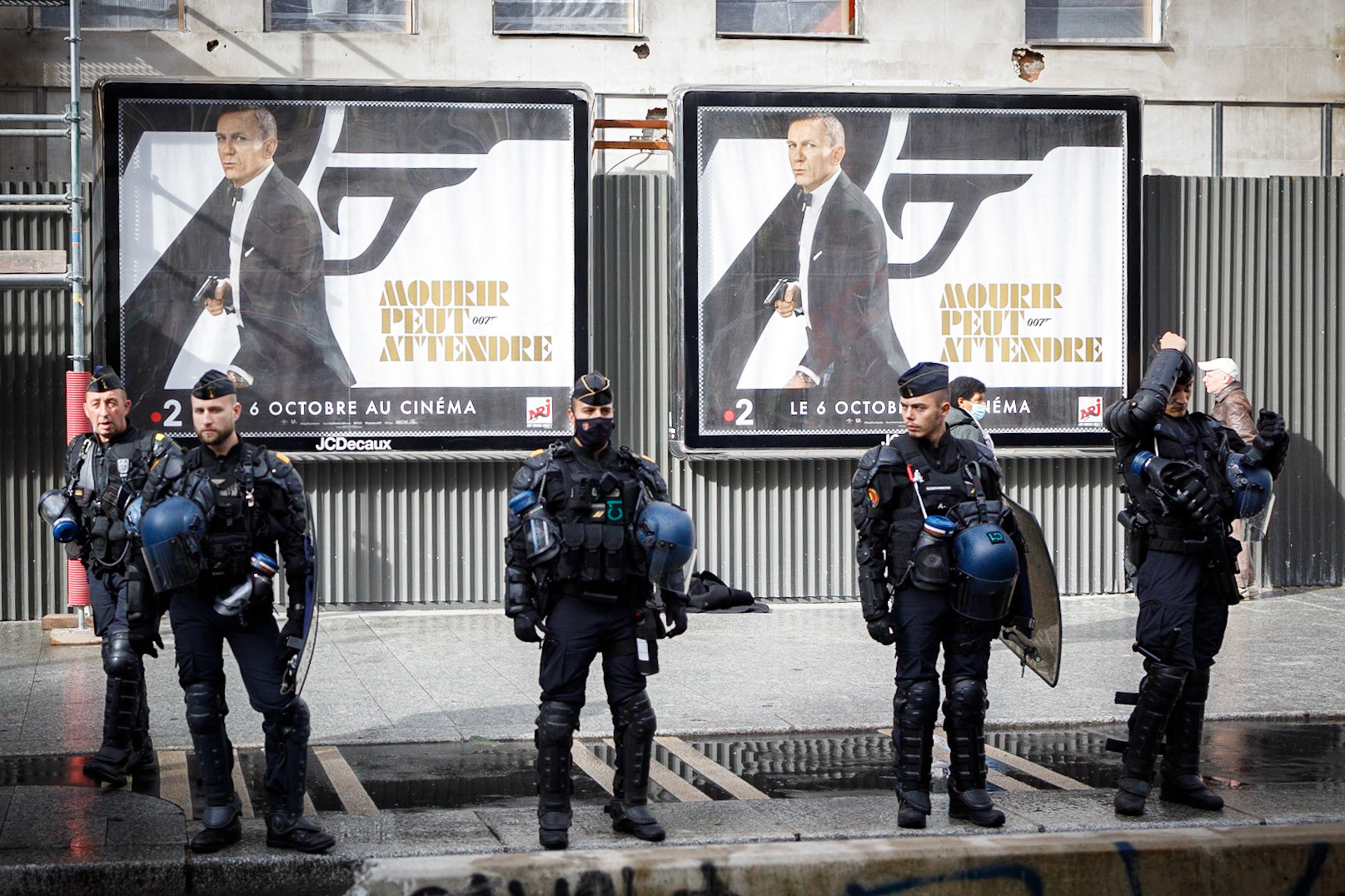Des gendarmes mobiles devant une affiche annonçant la sortie du James Bond “Mourir peut attendre” lors d’une journée d’action à Paris, le 5 octobre 2021. Cette manifestation à l'appel d’une intersyndical (CGT, FO, SNES-FSU, UNEF…) a pour revendications la défense des salaires et des emplois et contre la réforme des retraites.Paris, FRANCE - 05/10/2021