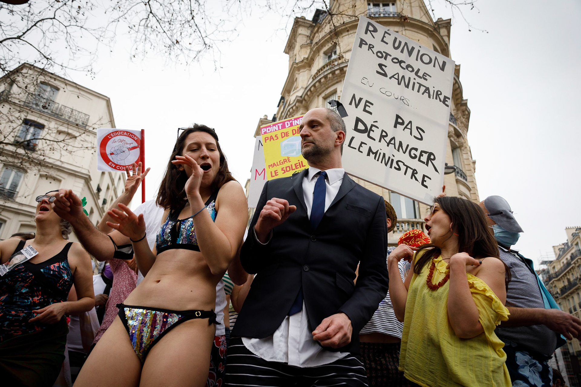 Des manifestants, dont un sosie de Jean-Michel Blanquer, dansent lors d'une manifestation intersyndicale pour une hausse des salaires, à Paris, le 27 janvier 2022. Ils parodient l’annonce du nouveau protocole sanitaire lors des vacances du ministre à Ibiza.Paris, FRANCE - 27/01/2022