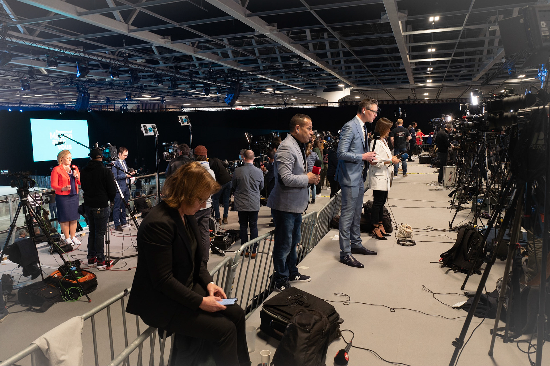 Des journalistes des télévisions française et internationale réalisent des duplex en direct du parc des expositions à Paris. Emmanuel Macron et la majorité présidentielle (LREM) ont réuni des militants pour la soirée du premier tour de l'élection présidentielle, le 10 avril 2022.PARIS, France - 10/04/2022