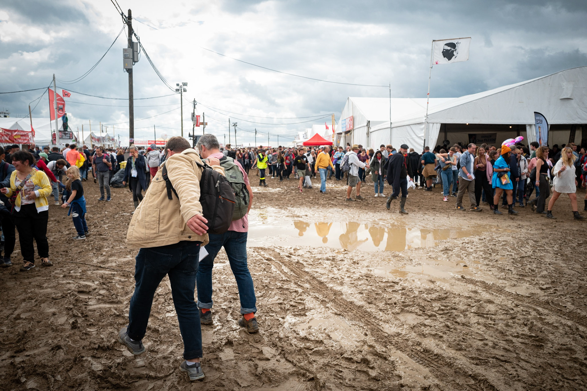 Les visiteurs de la fête de l'Humanité marchent dans les allées, remplies de boue, le 10 septembre 2022 au Plessis-Pate. France, Le Plessis-Pate, 10-09-2022
