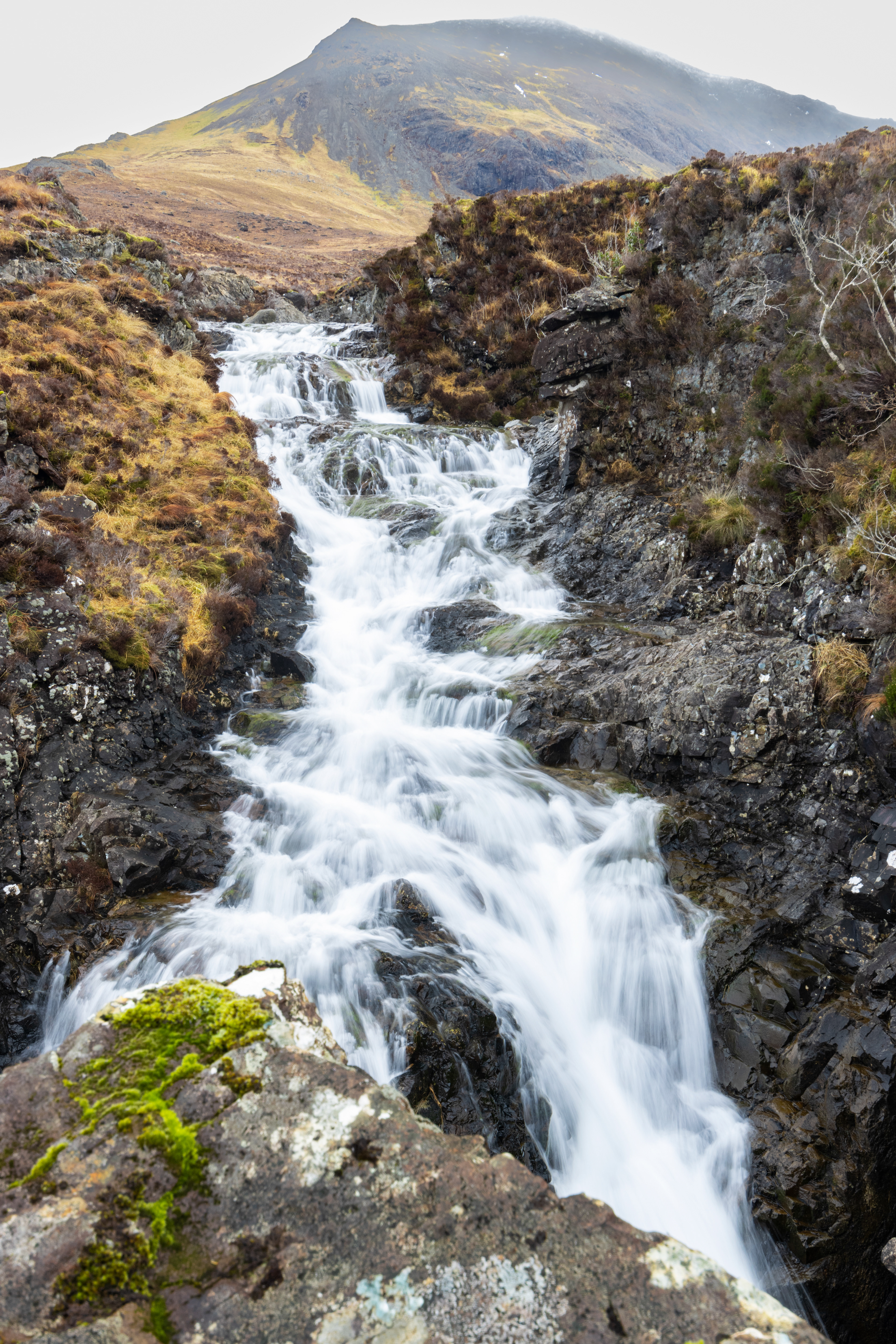 A waterfall cascading through a narrow, rocky gorge.