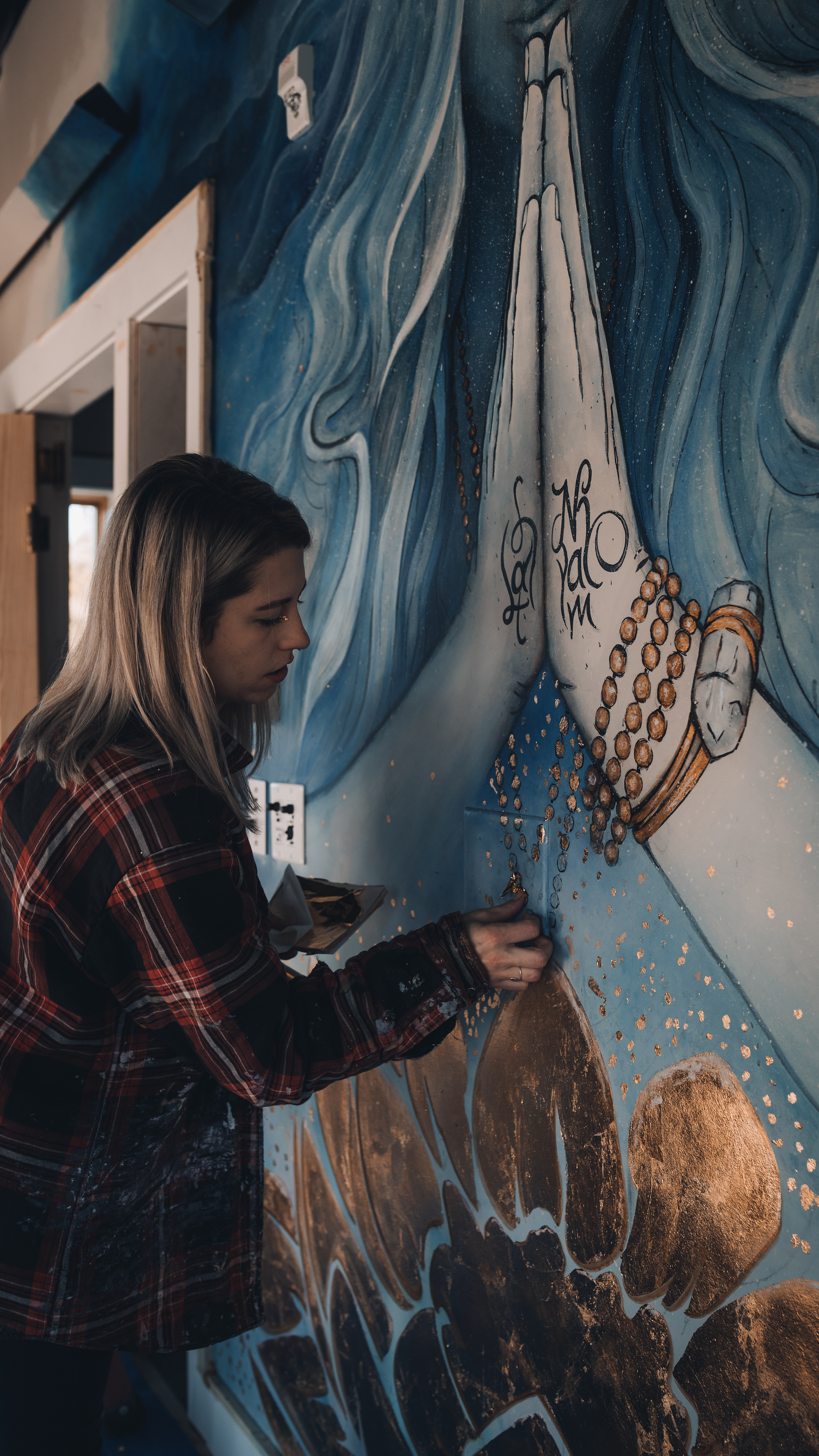 Woman painting with gold foil leaf