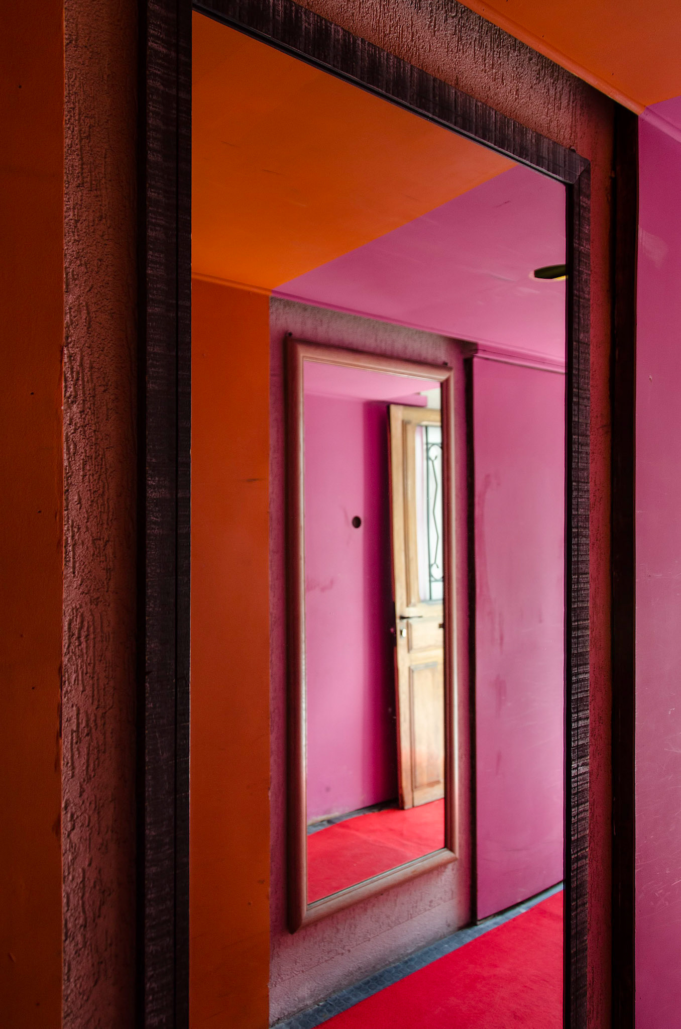 Reflections of a red hallway leading to an art gallery in Paris, France
