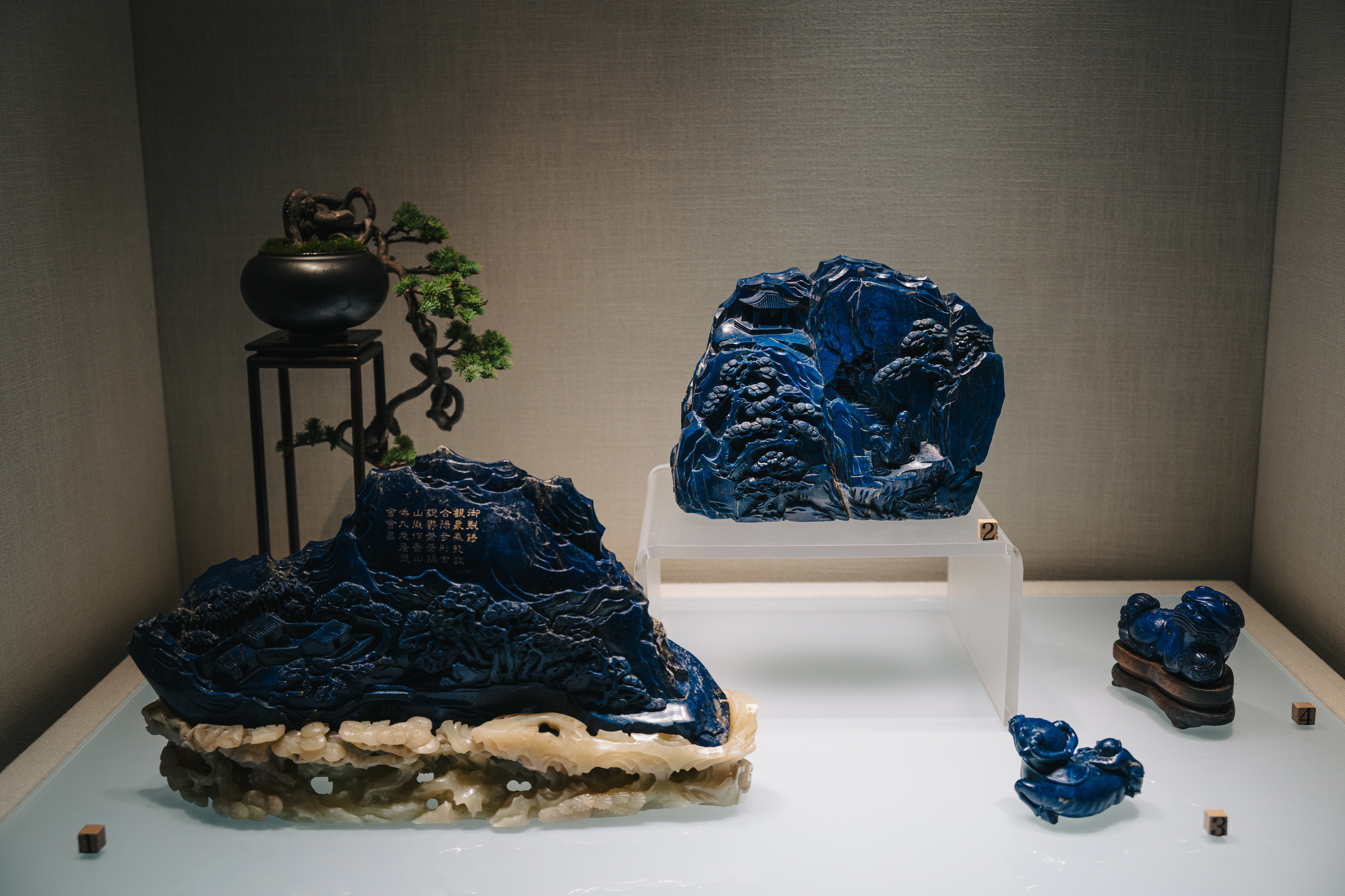 青金石雕山水图(左),松泉人物图(中),卧牛(右)