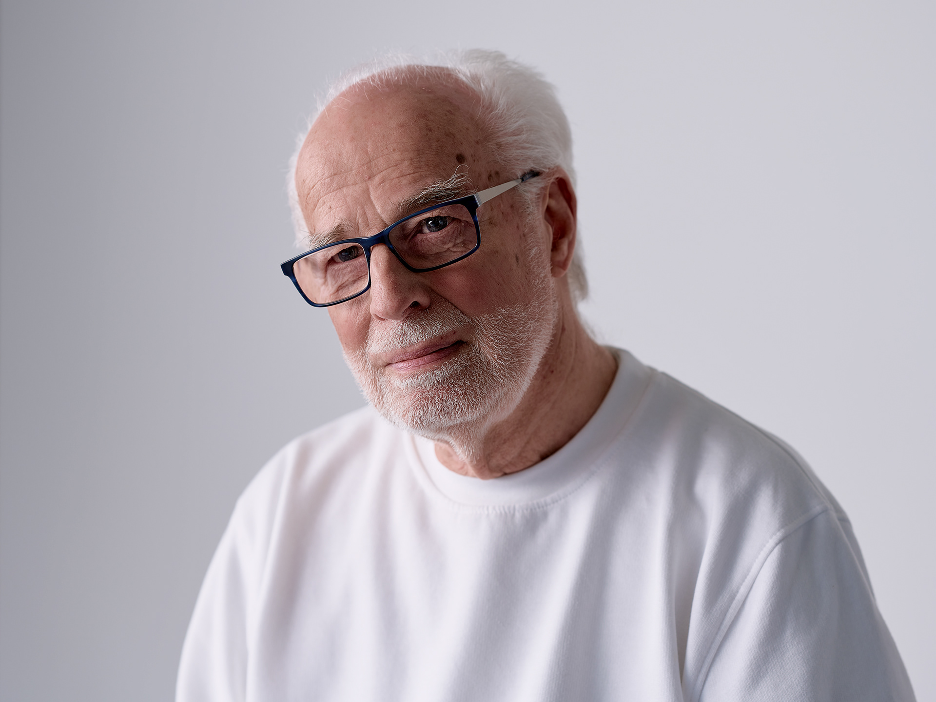 older man with glasses and white shirt