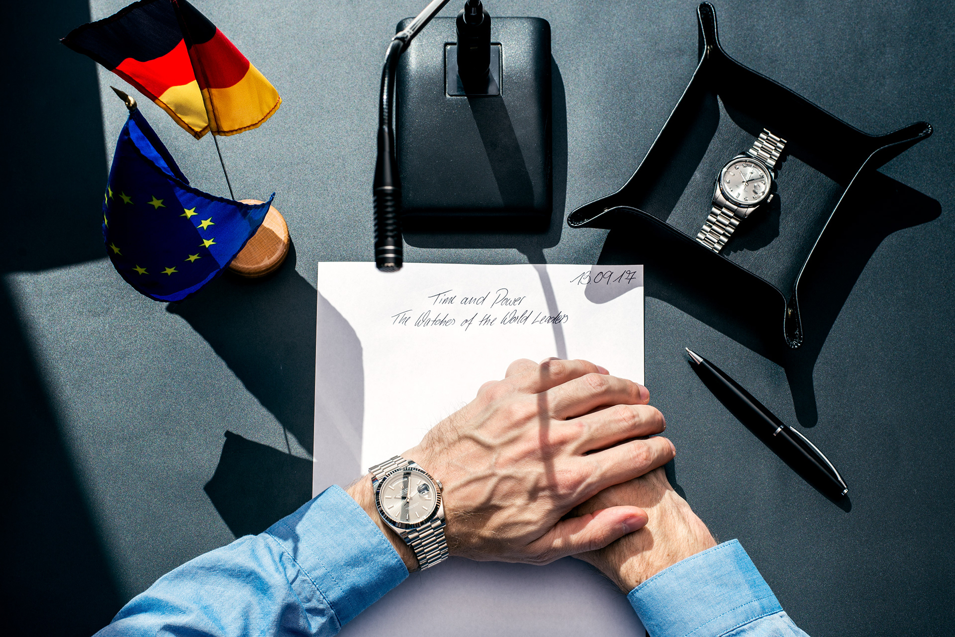 politiker sitzt am pult mit rolex luxusuhr am arm