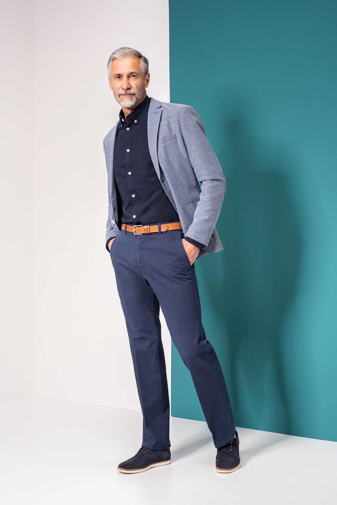 Mann steht vor weißer und türkiser Wand