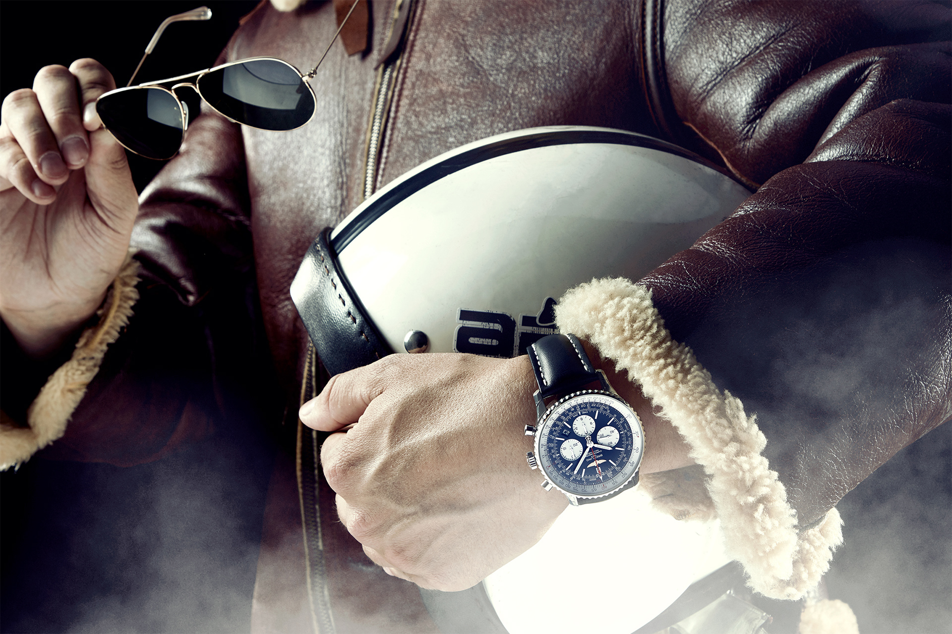 pilot mit fliegerbrille und breitling luxusuhr am arm