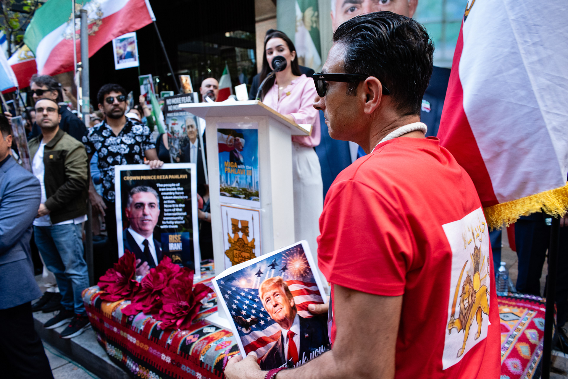 North Sydney, Australia. 11th Apr, 2026. A man walks walks by the speakers podium with a poster of United States president Donald Trump that reads “Thank You” at a rally outside the United States Consulate General at 50 Miller Street in North Sydney. The rally is part of a coordinated global day of action organised by parts of the Iranian diaspora supporting former Crown Prince Reza Pahlavi.