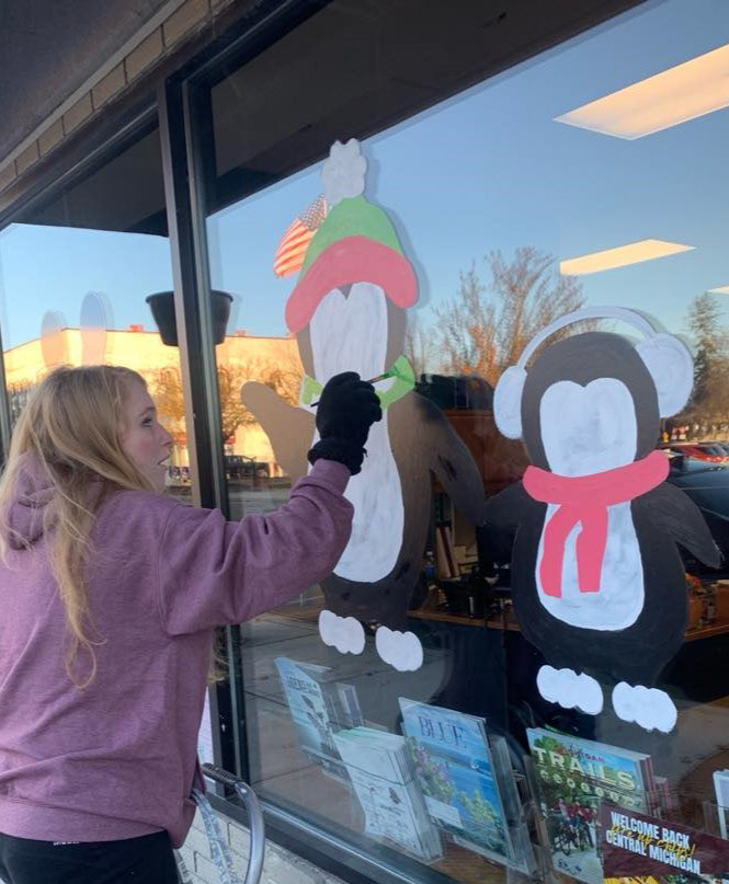 An image of me painting a window for the City of Mt. Pleasant