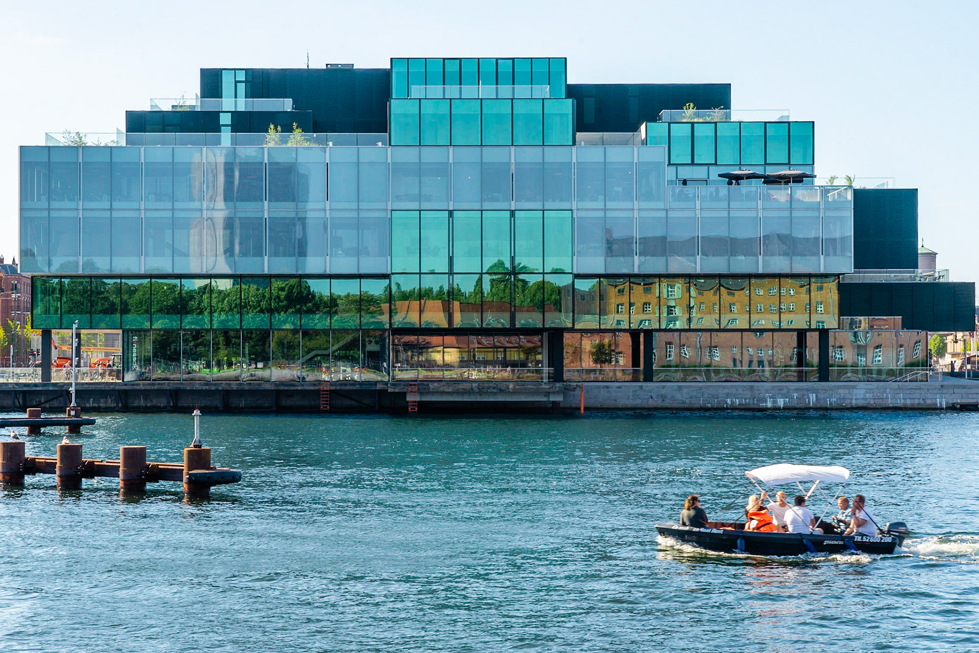 The Blox building from 2018 by the Copenhagen waterfront, domicile for DAC, Dansk Arkitektur Center. Leisure boat in front.