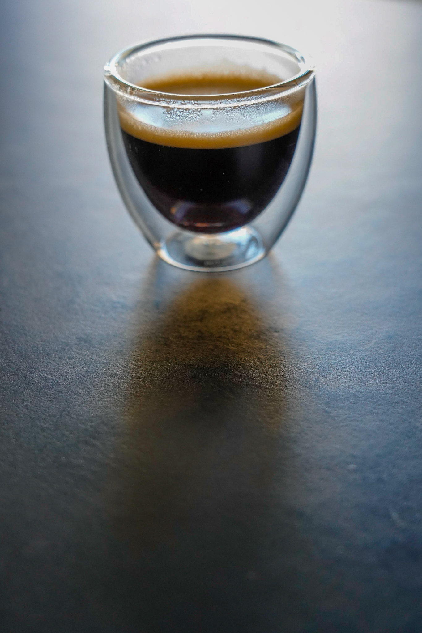 Glass coffee cup from Bodum with espresso on black background