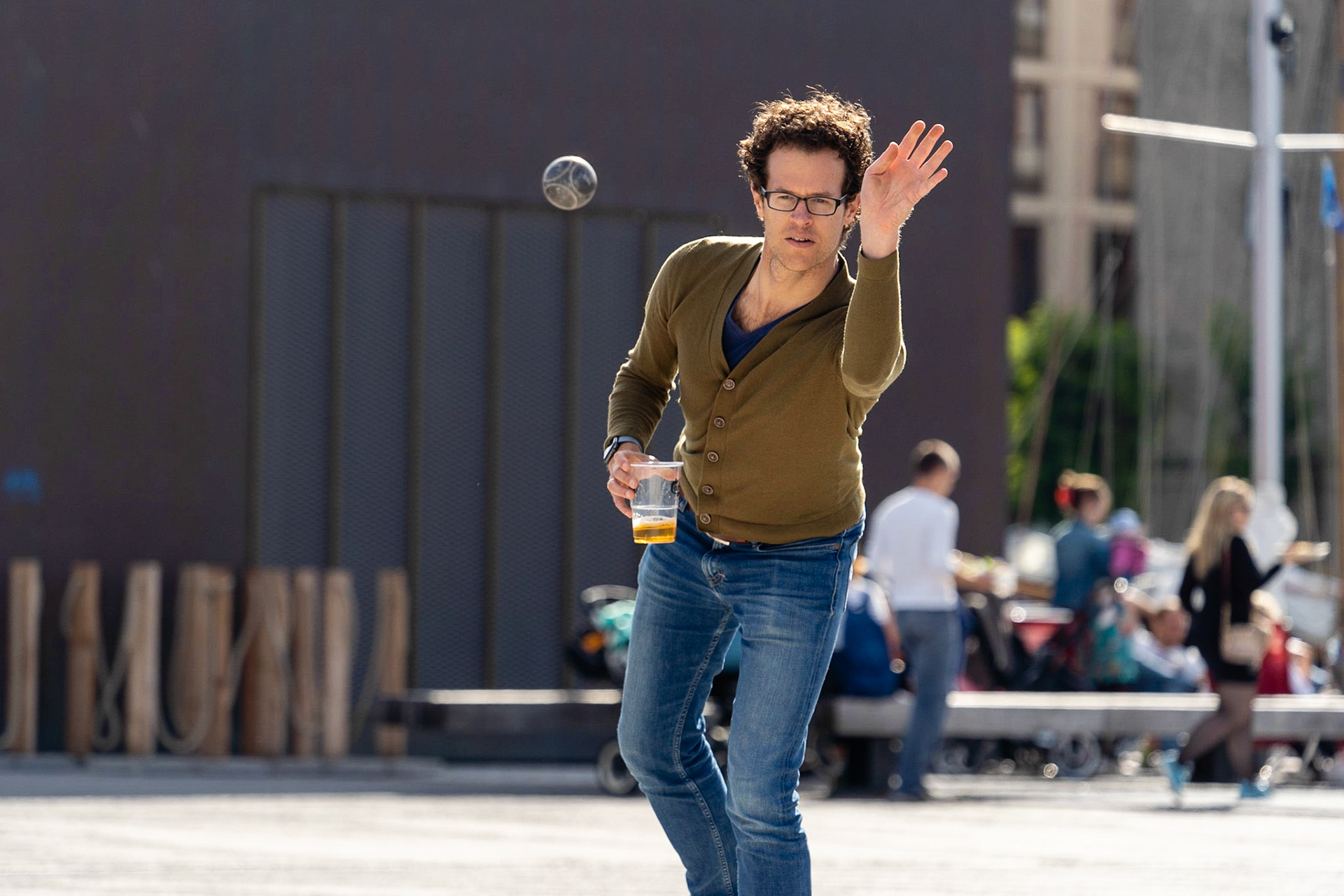 Man in thirties with glasses playing petanque at Ofelia Square (Ofelia Plads) by the Copenhagen waterfront