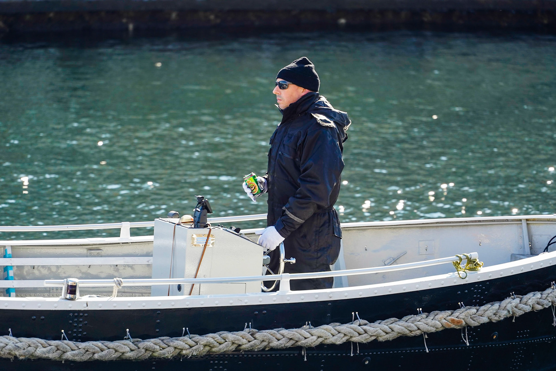 Man on a boat in a Canal in Copenhagen, Denmark, Danish flag Dannebrog, relaxing, having a Tuborg Classic beer