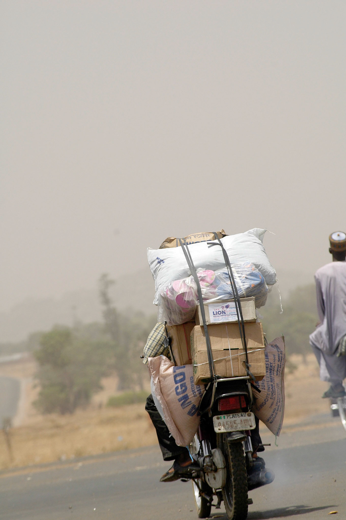 Een typisch beeld van een volgepakte brommer, waarvoor dit veelvoorkomend vervoersmiddel veel gebruikt wordt. Zaria (Nigeria) 11 april 2006