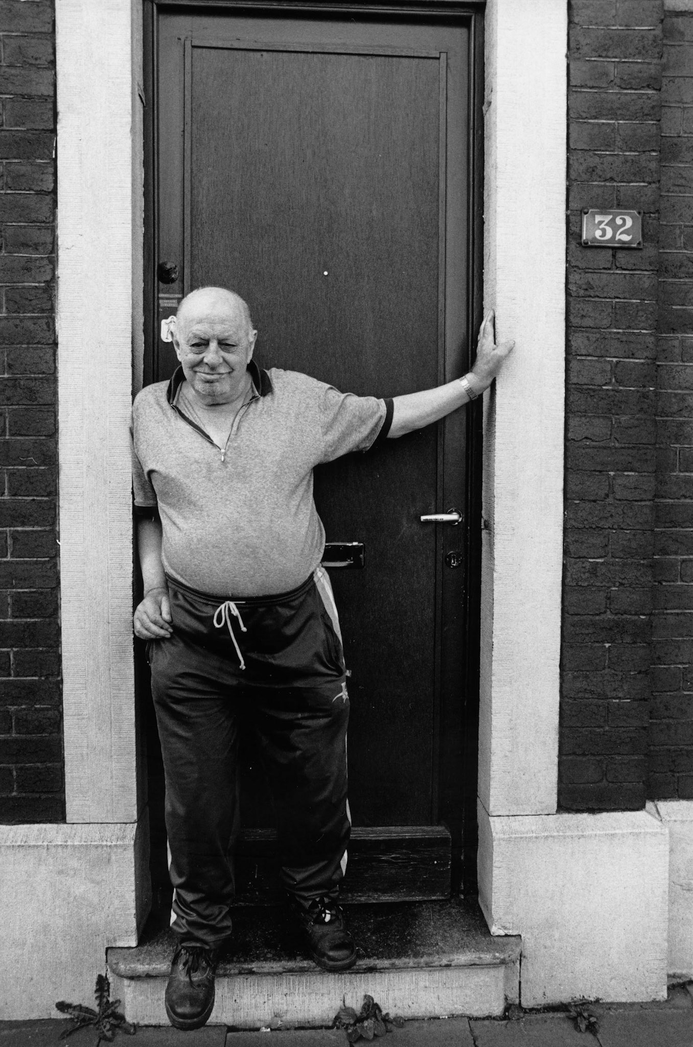 Man neemt een kijkje buiten zijn voordeur, Seraing, nov. 2002 
"Onder industrieele vleugels" Maassteden in Wallonie.