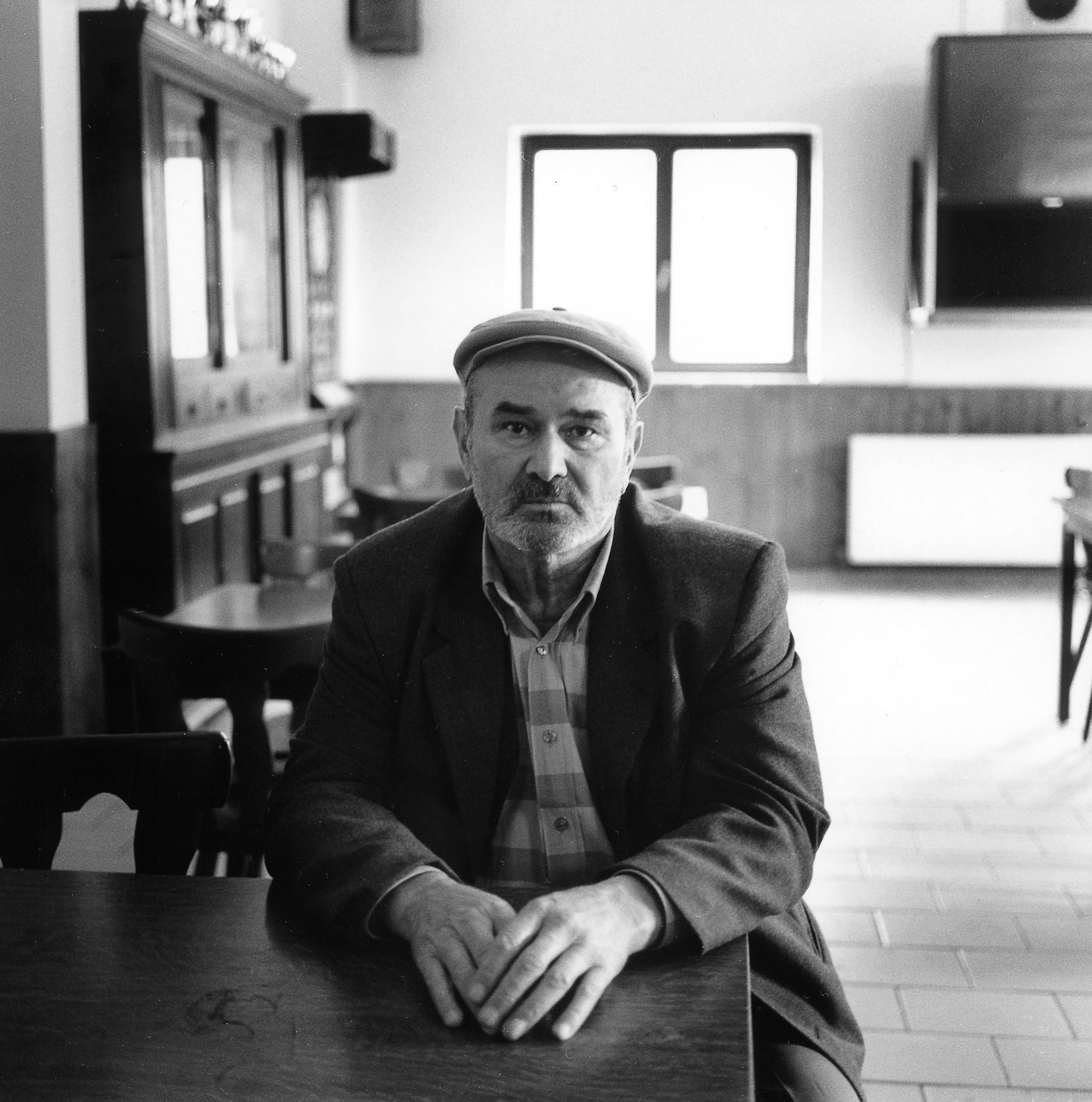 Man aan tafel in verblijfsruimte van Moskee, Cheratte, sept. 2002 "Onder industrieele vleugels" Maassteden in Wallonie.