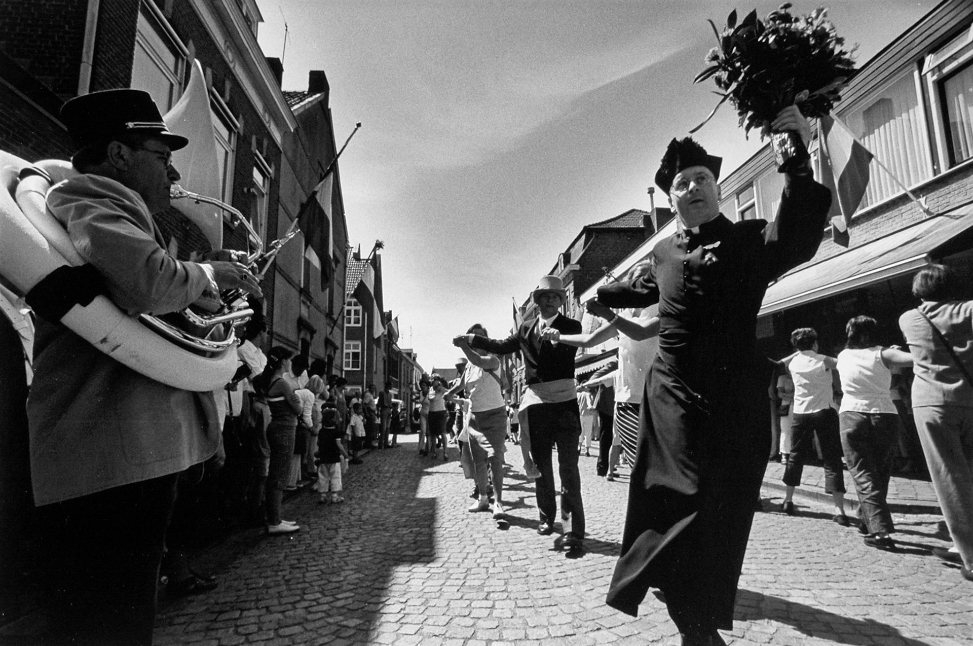 De pastoor gaat voorop bij het dansen van de Cramignon tijdens de "Broonk" in Eijsden, juni 2002.