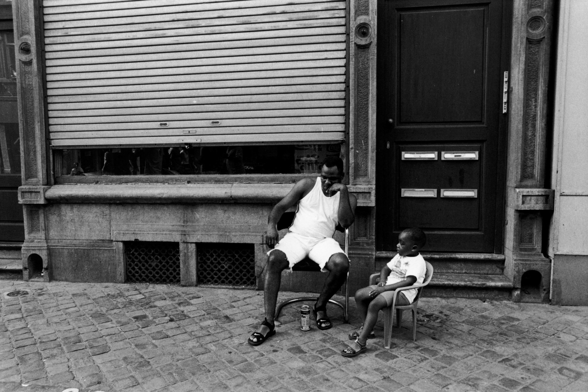 Man zit samen met zoon buiten te genieten van het weer tijdens het Sainte Marie festival, Luik 2001