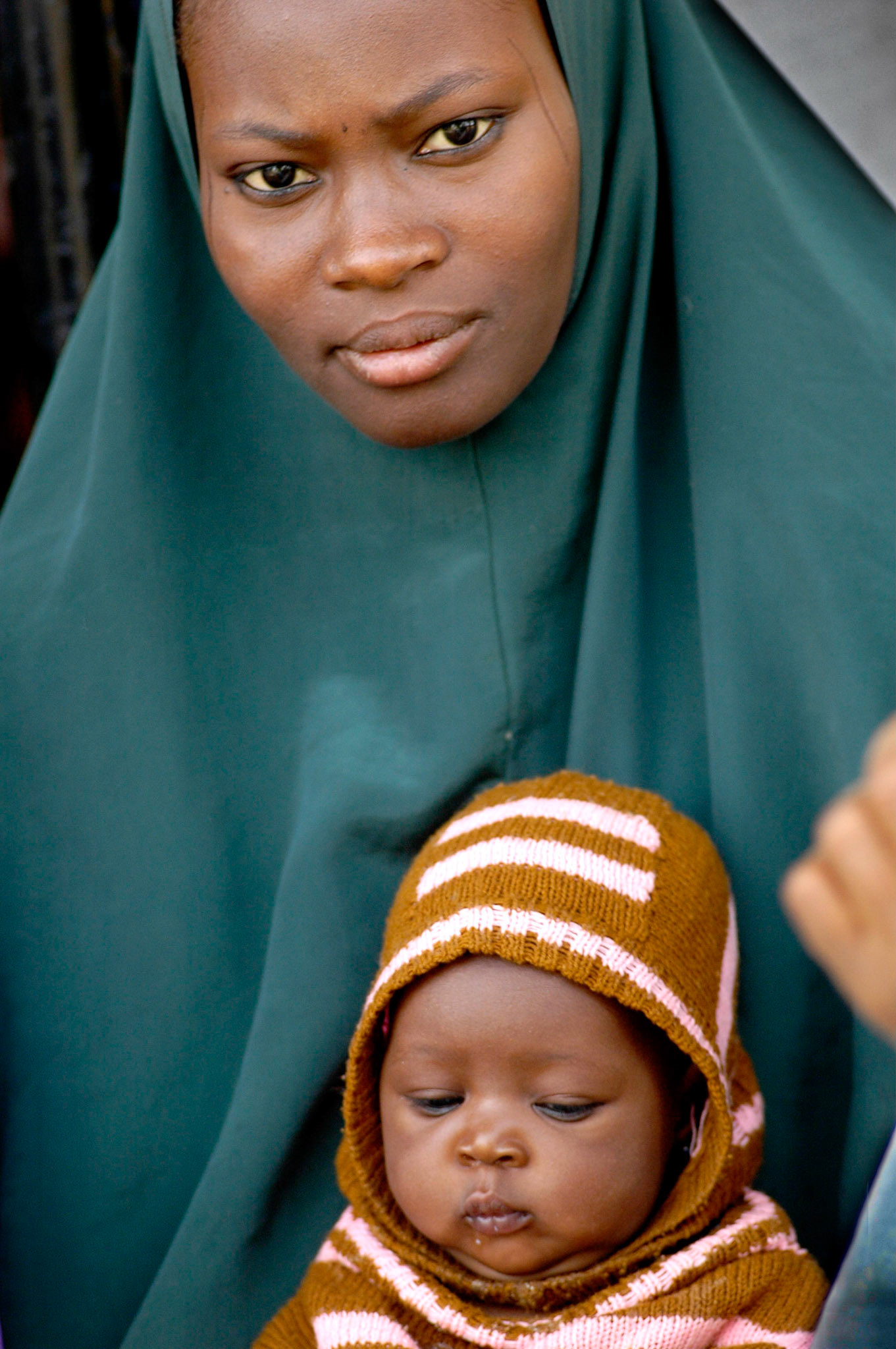 Moeder met kind wacht voor behandeling bij de Almadina Pharmacie, Zaria (Nigeria) 11 april 2006