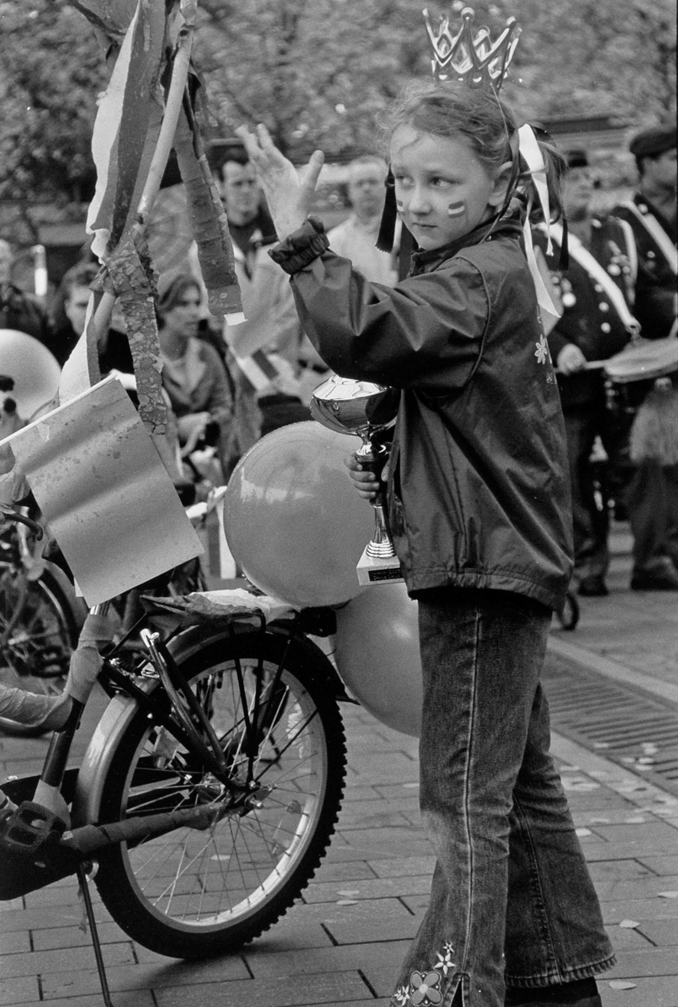 Meisje maakt handgebaar tijdens de versierde kinderfietstocht op Koninginnedag in Venlo, 30-4-2003