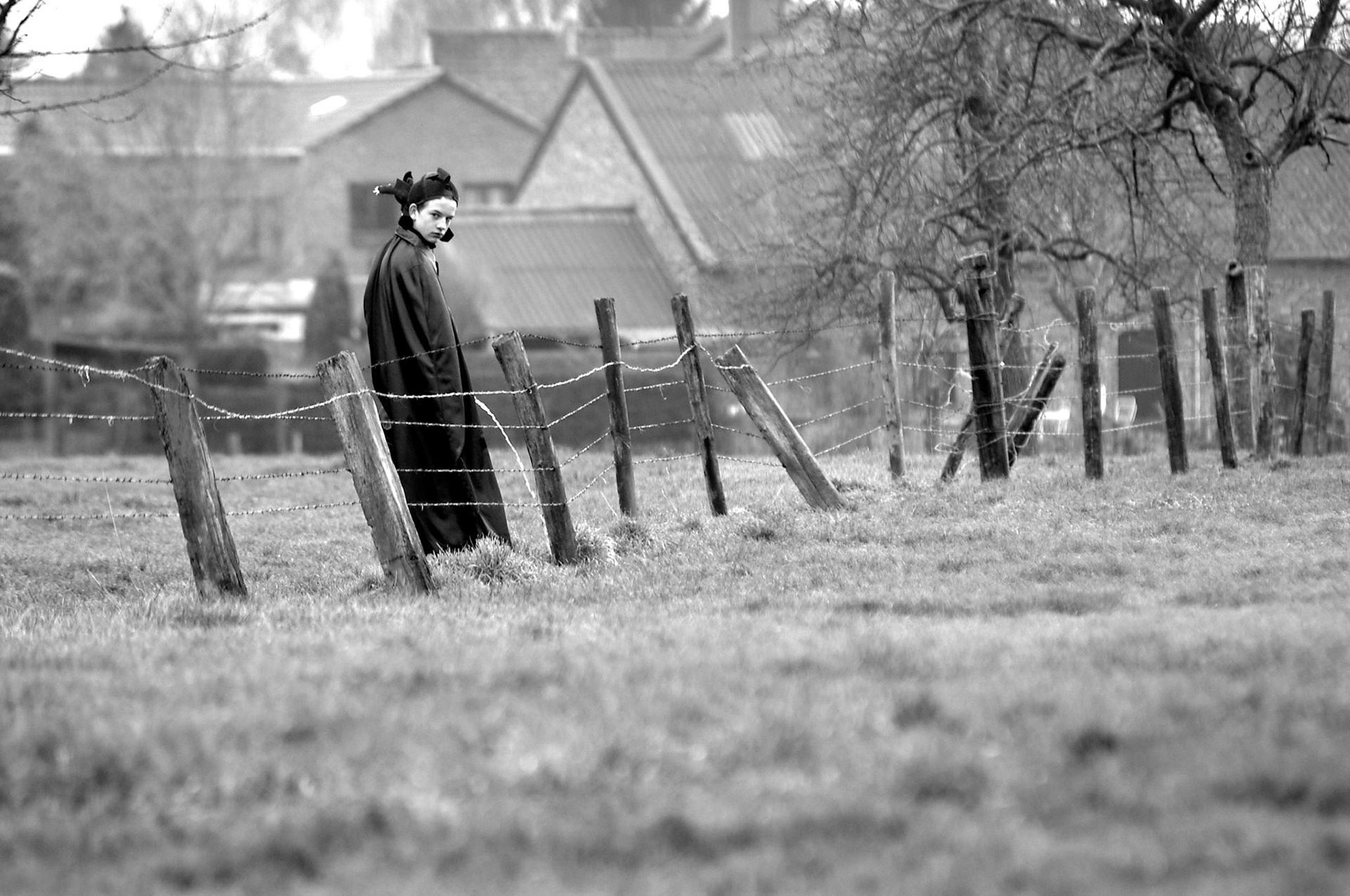 Jonge duivel doet behoeft in het veld tijdens de carnavalsoptocht in Mesh, 5-2-2005.