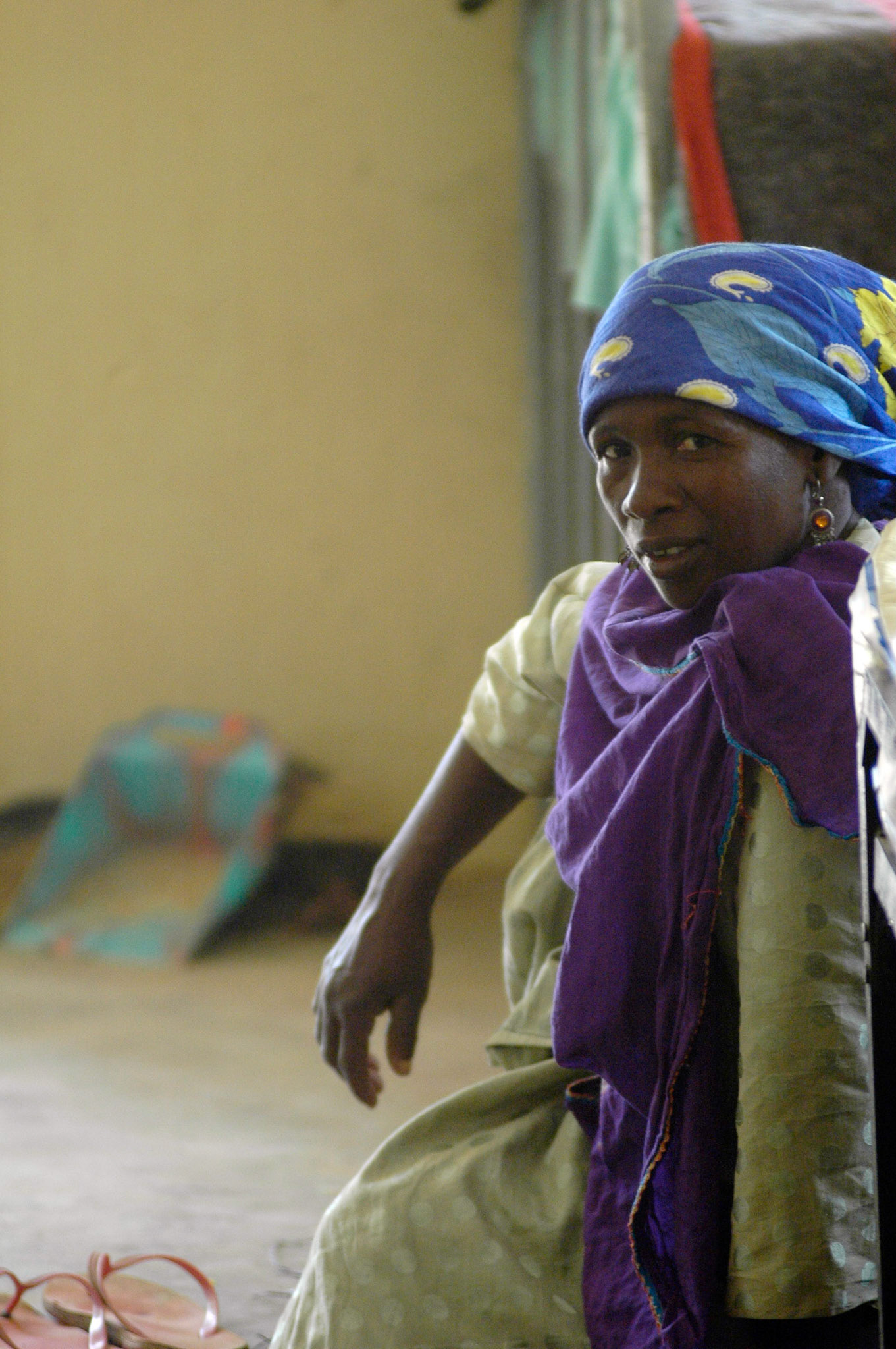 Vrouw zit naast het bed van haar, voor lepra in behandeling zijnde man. NTBLTC Lepra en TBC hospital, Zaria (Nigeria) 11 april 2006