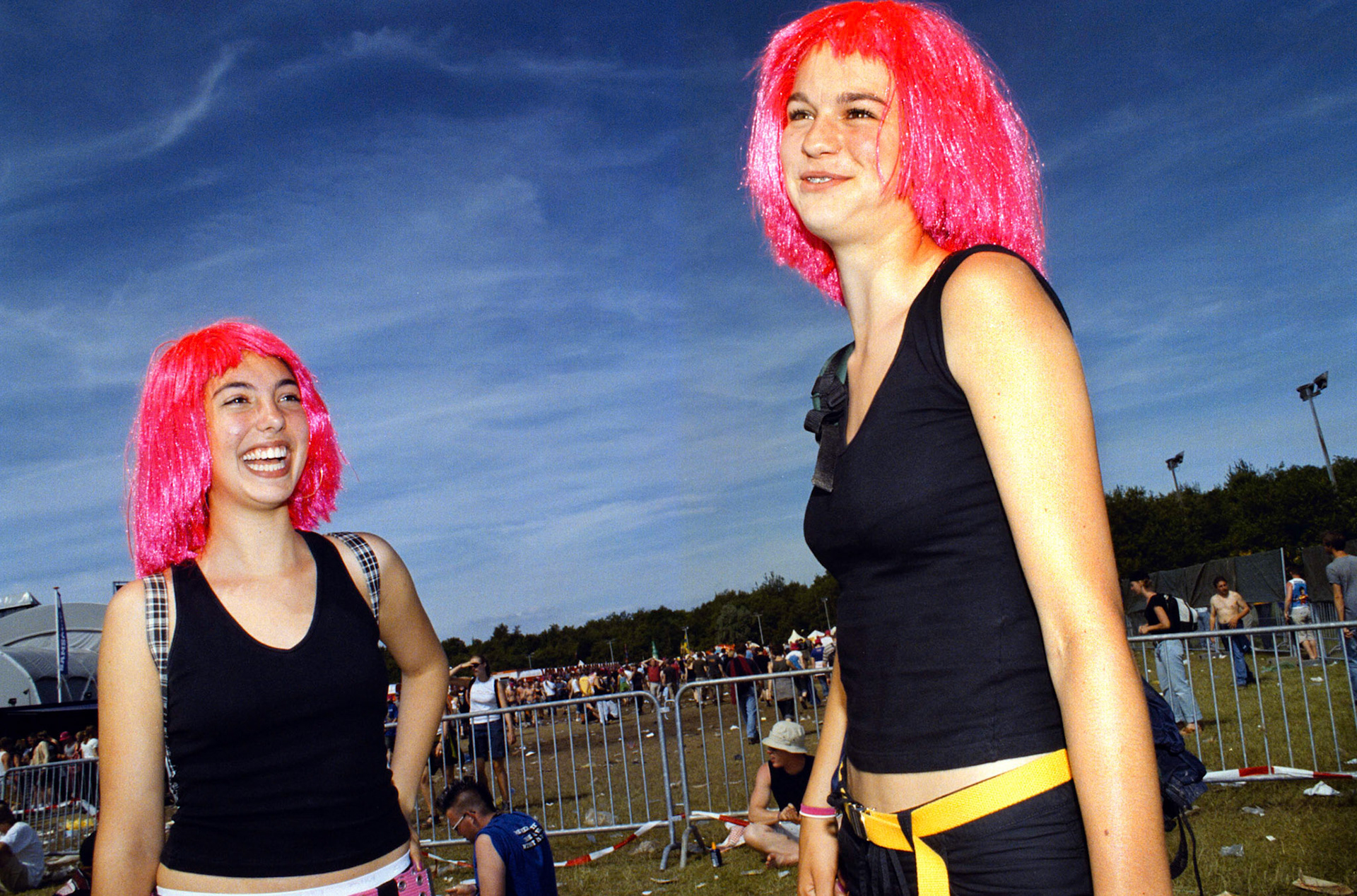 Meisjes met roze pruiken tegen blauwe lucht. Sfeeropname van Pinkpop 2003