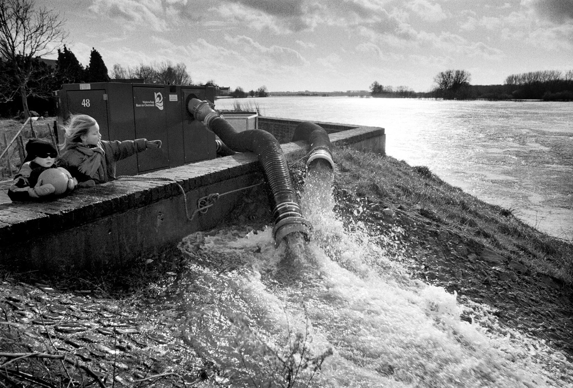 Kinderen kijken naar het pompen van water tijdens hoogwater in Itteren. Het waterpeil bedraagt hier 45 meter. Itteren, 27 feb 2002