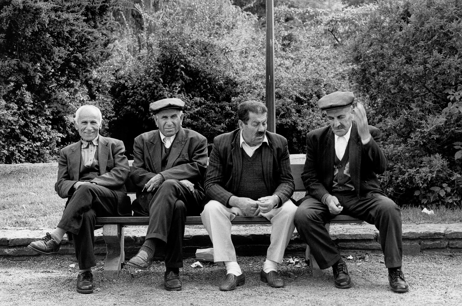 Vier Turkse mannen houden een conversatie op een bankje in Luik, Aug. 2002