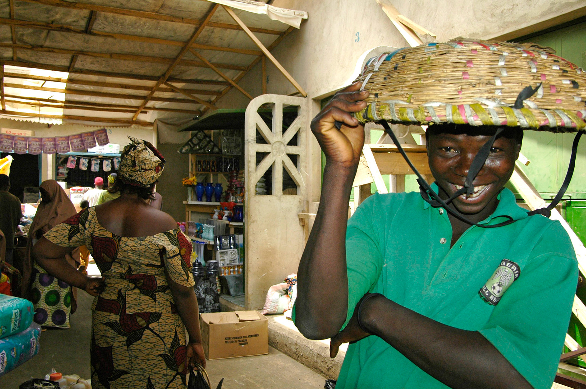 Een lachende boodschappendrager op de Kaduna Market, Zij dragen de boodschappen van klanten op de markt, voor een kleine vergoeding, in een mand op hun hoofd. Nigeria 4 april 2006