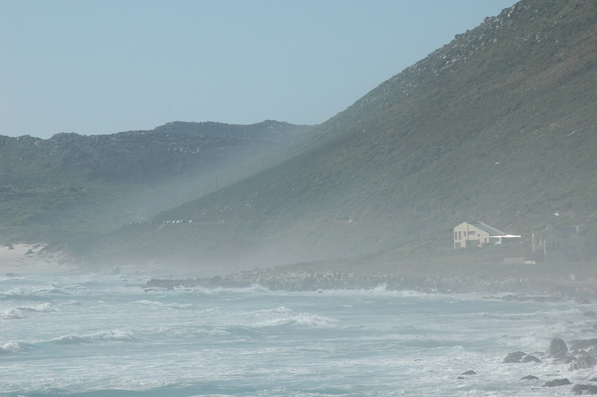 Het opspattende zeewater zorgt voor een mistige waas over het strand van Houtbay, Zuid-Afrika 7-1-2008