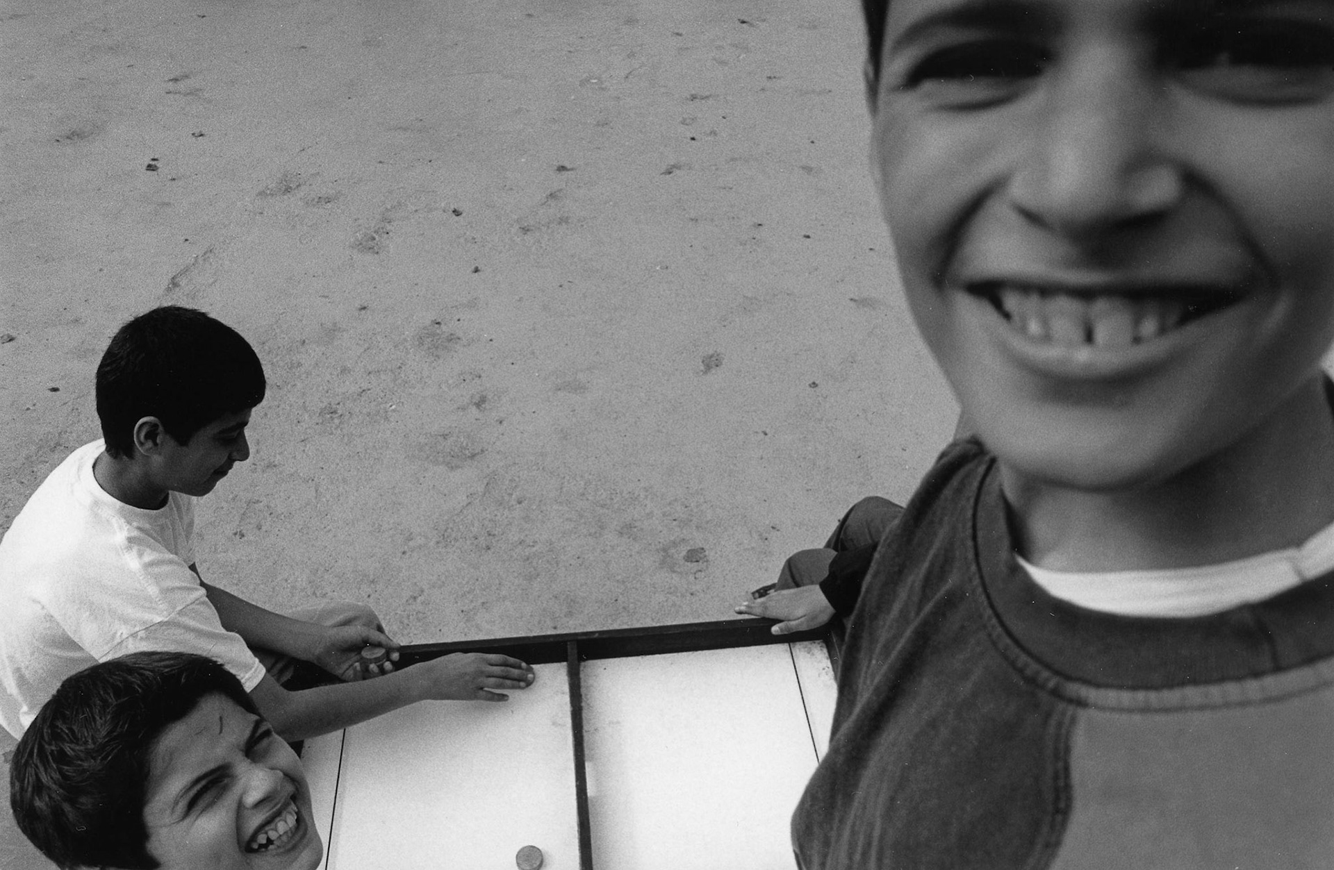 Kinderen doen een bordspel op het plein in de wijk Droixe, Luik sept. 2002