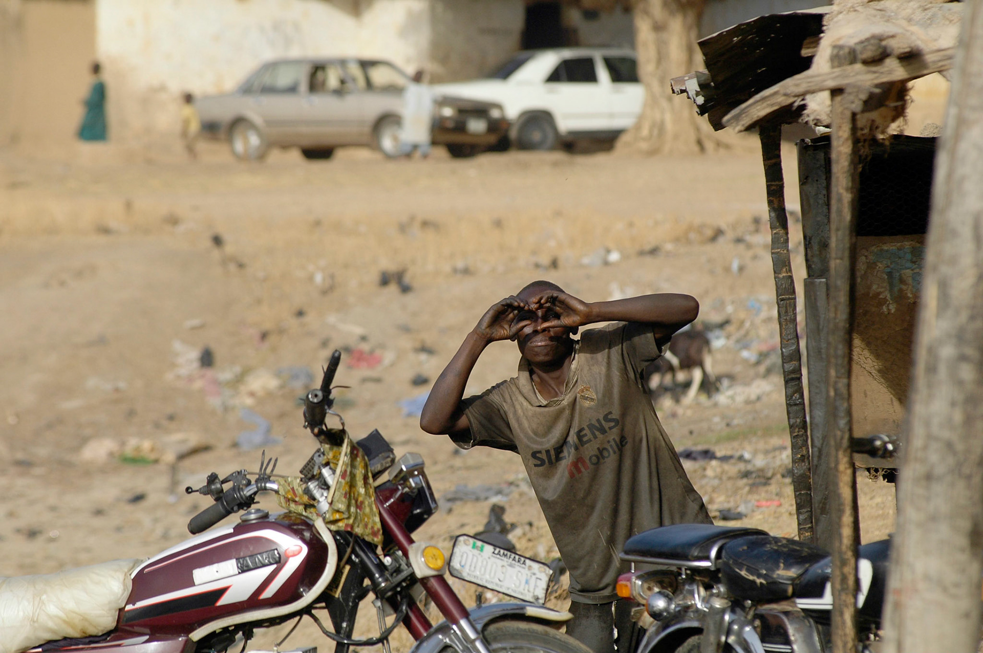 Deze komische brommer reparateur had duidelijk in de gaten dat hij gefotografeerd werd, Zaria (Nigeria) 11 april 2006