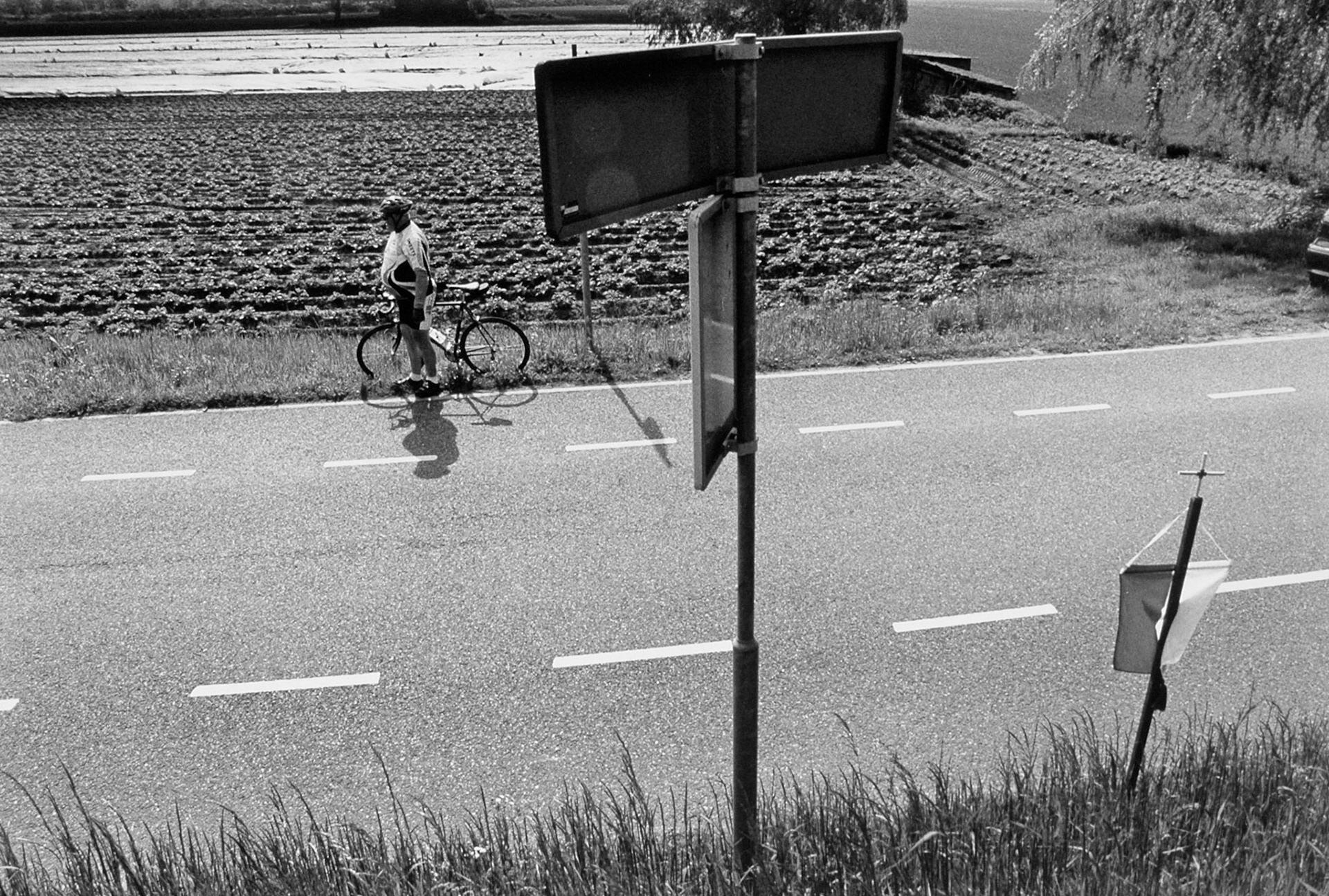 Wielrenner kijkt toe hoe de processie nadert, Processie Biesland, Maastricht 11-5-2003