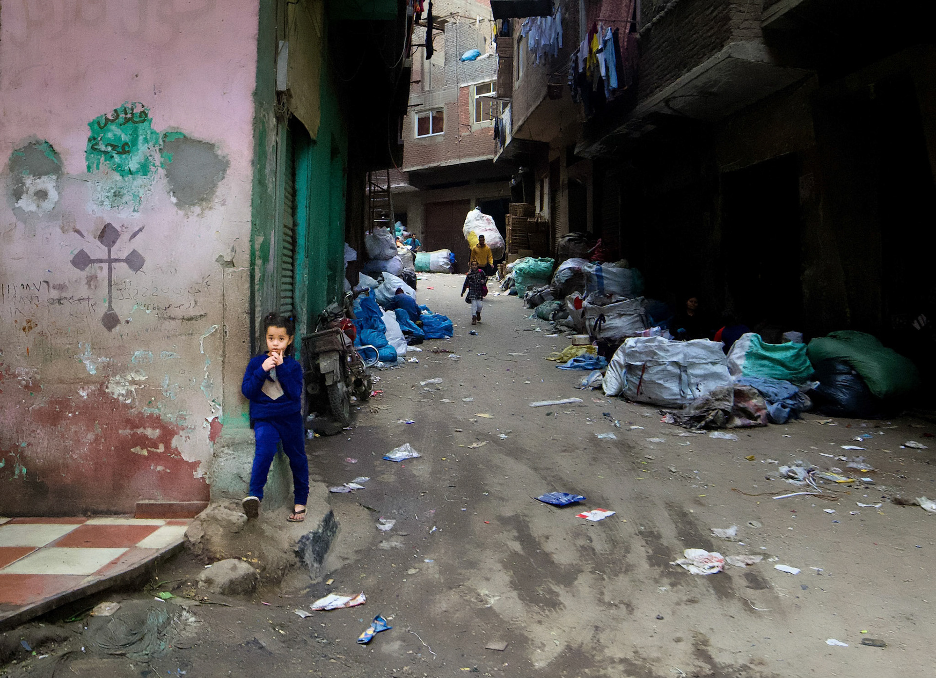 This little girl lives in Garbage City, Cairo.  Most residents are Coptic Christians, as you can tell from the cross to her right.  