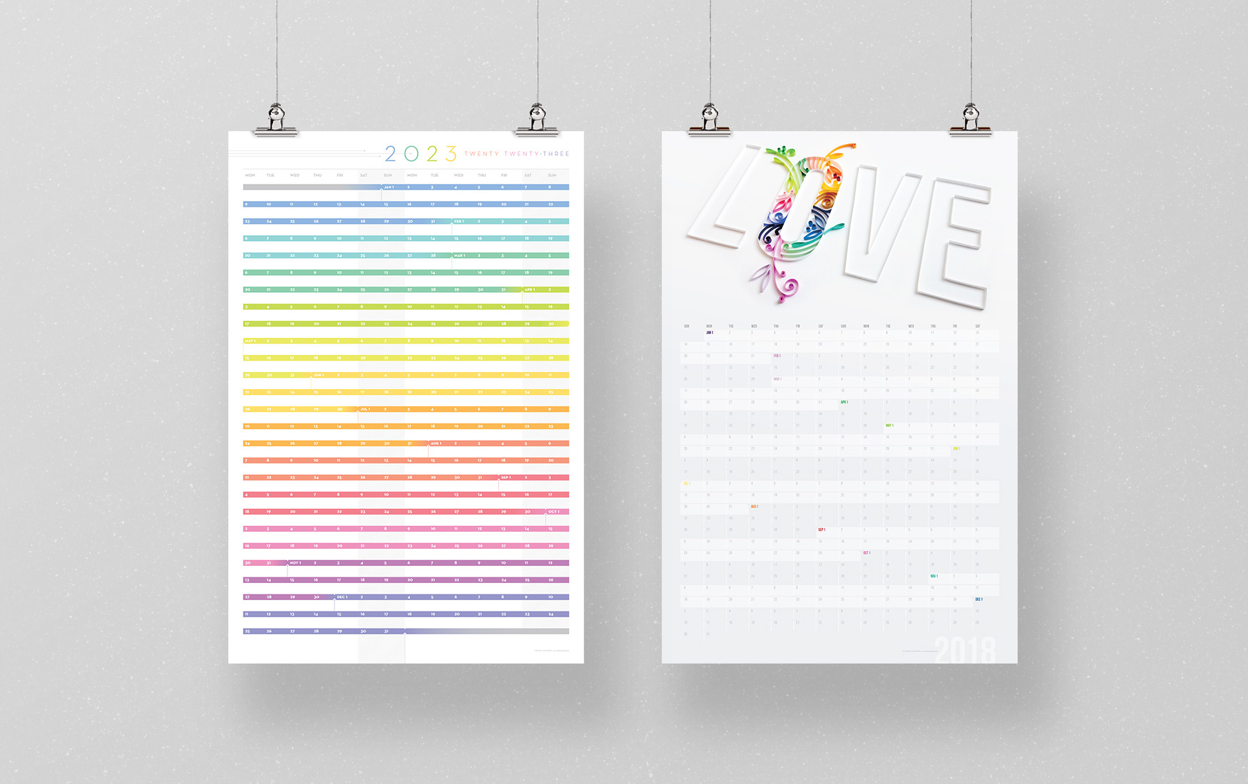 Two poster sized wall calendars with rainbow colors and paper quilling designs.