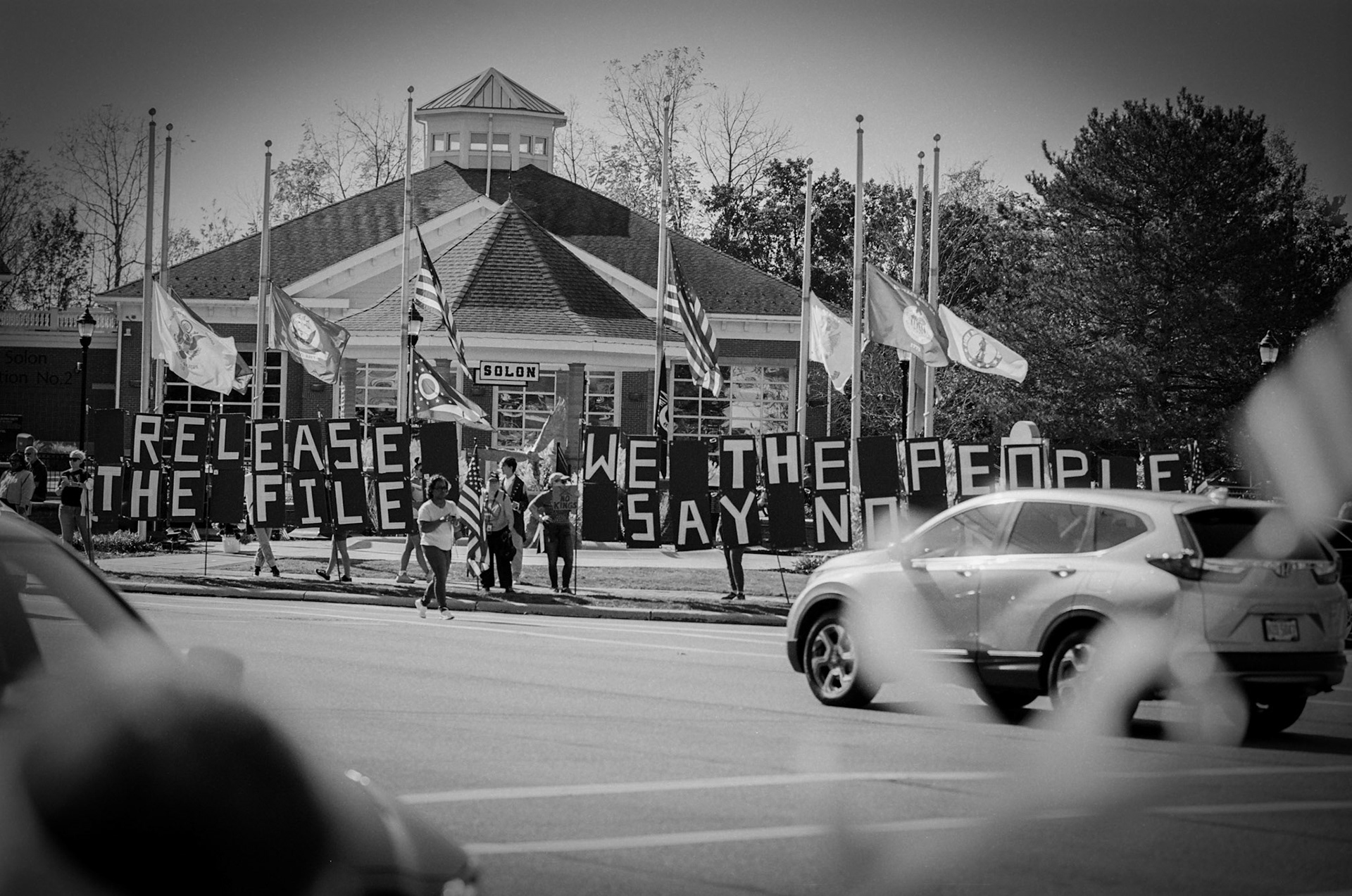 Protesters line SOM Center Road in Solon, OH on October ## 2025 to demonstrate against the Trump presidency and newly implemented policies on immigration.