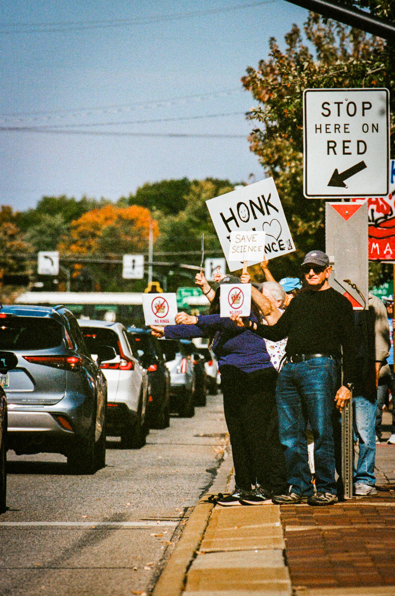 Protesters line SOM Center Road in Solon, OH on October ## 2025 to demonstrate against the Trump presidency and newly implemented policies on immigration.